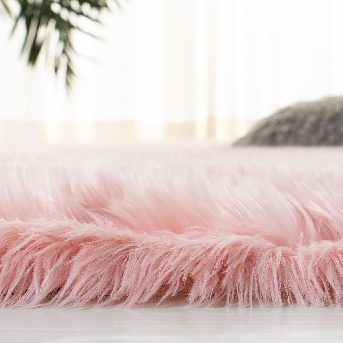 Side close-up of a plush pink faux sheepskin rug showing its long fibers and thick pile || FSS235G-5 || detail_room