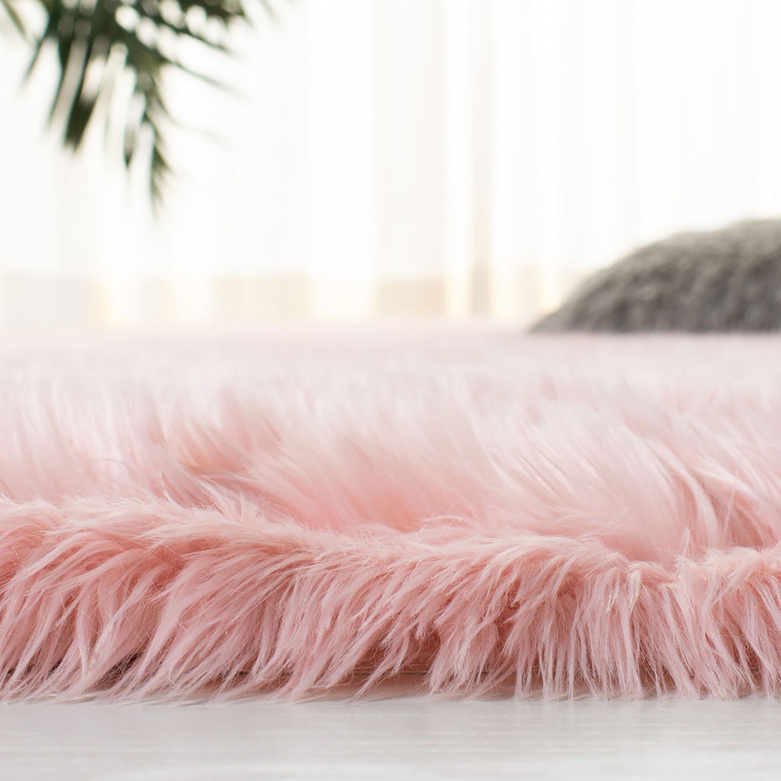 Side close-up of a plush pink faux sheepskin rug showing its long fibers and thick pile || FSS235G-5 || detail_room
