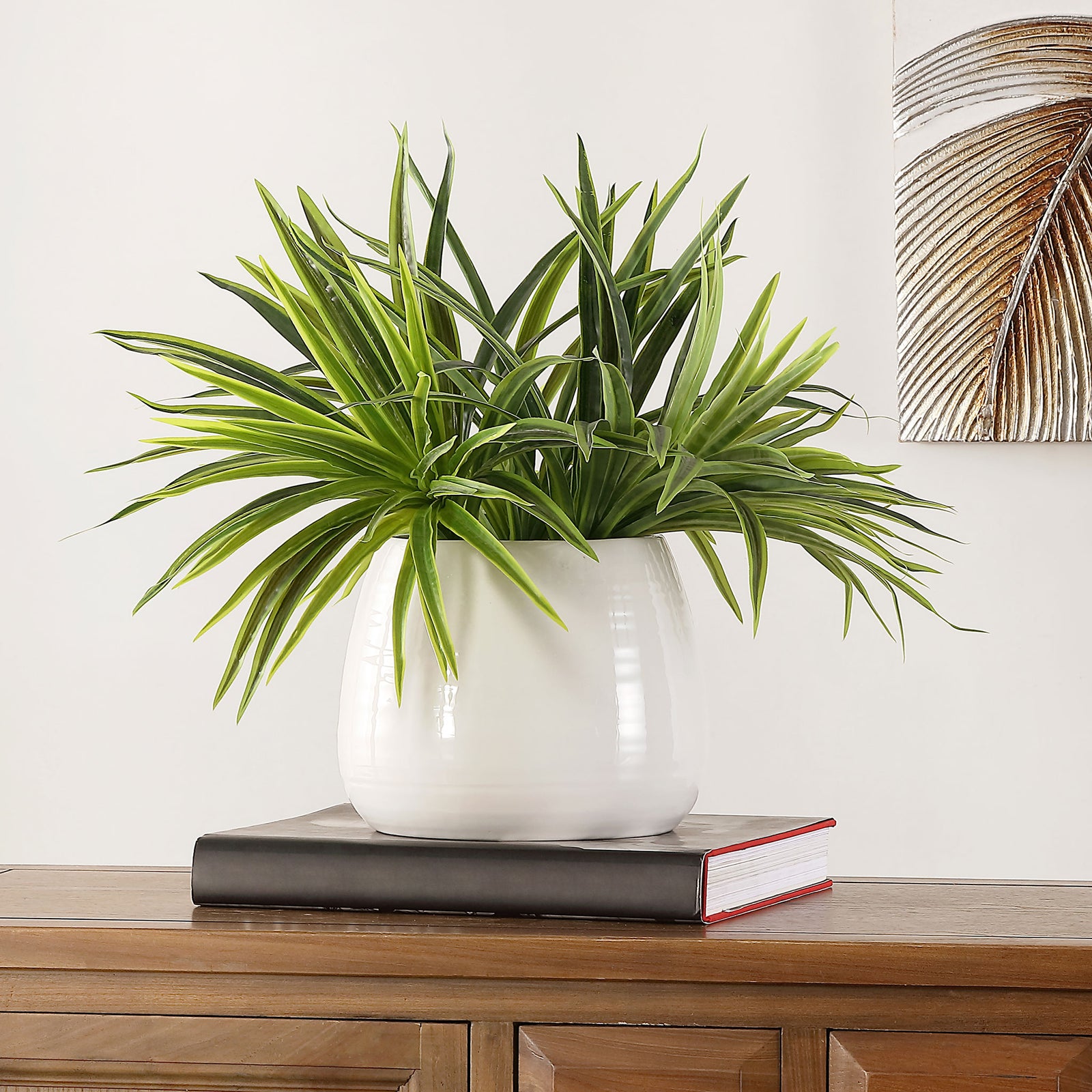 Striped green foliage spills from a rounded white pot on a console. || FXP1012A || front_room