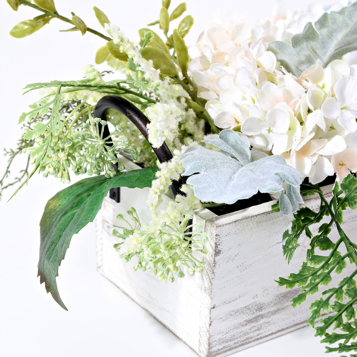 Pale blossoms mingle with silvery leaves beside a whitewashed wood box. || FXP1014A || detail_studio