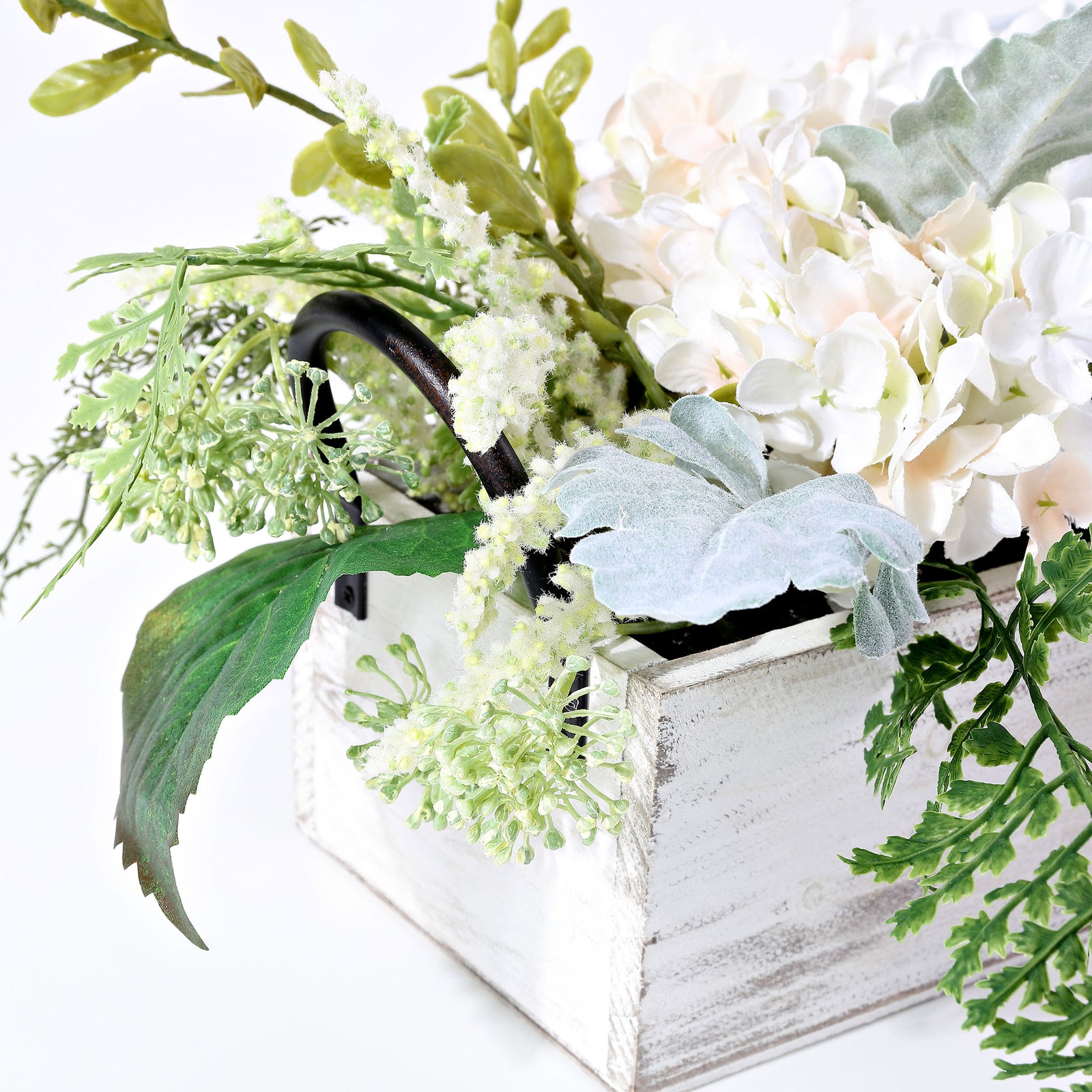 Pale blossoms mingle with silvery leaves beside a whitewashed wood box. || FXP1014A || detail_studio