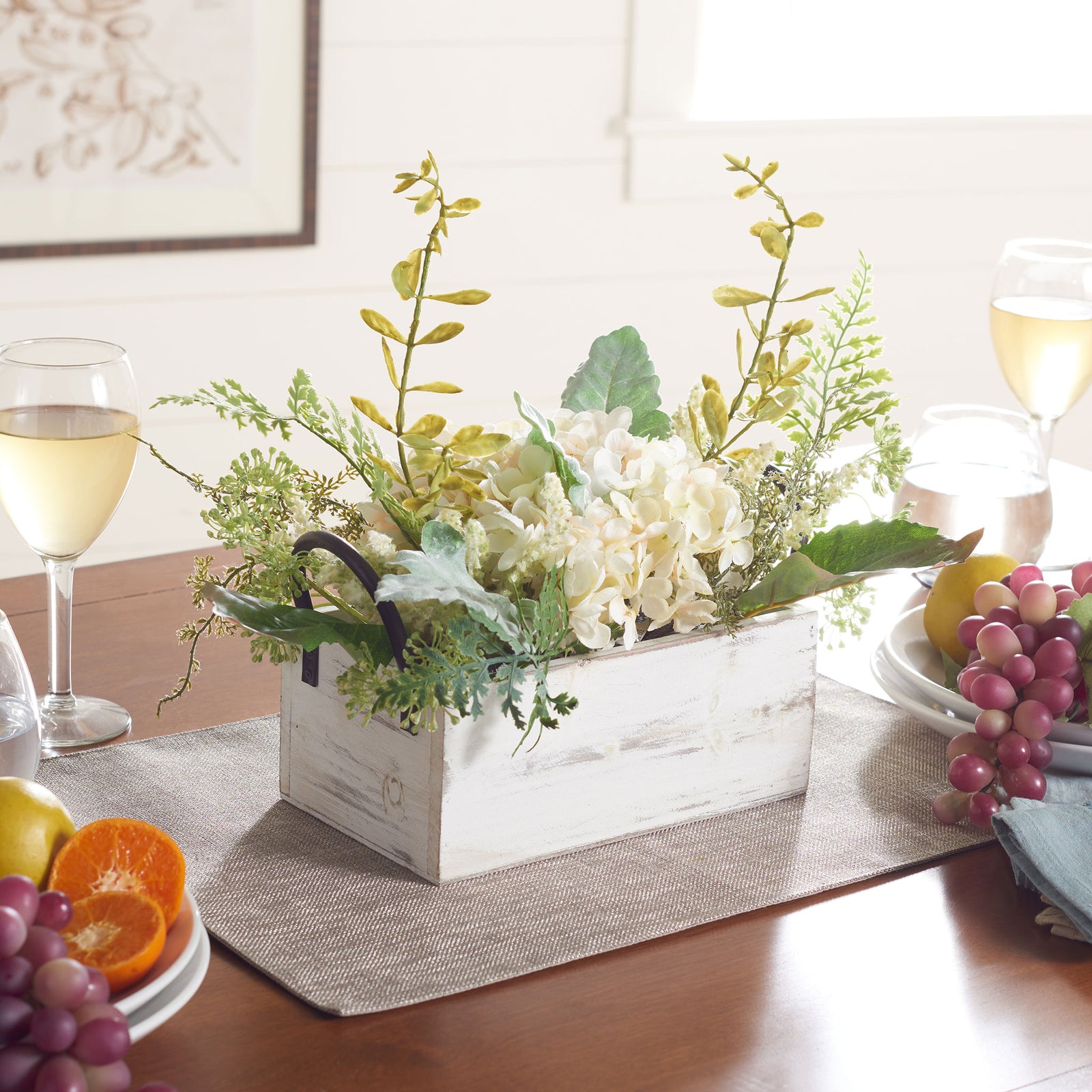 A white floral arrangement adds a soft botanical accent to a dining table. || FXP1014A || front_angle_room
