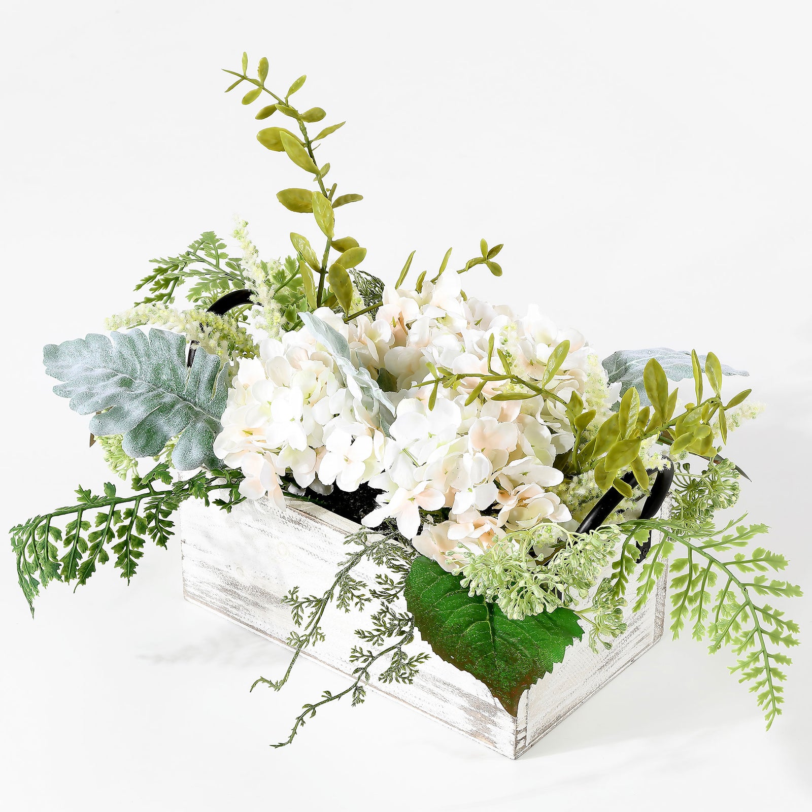 Lush green stems spill around ivory hydrangeas in a whitewashed planter. || FXP1014A || front_angle_studio