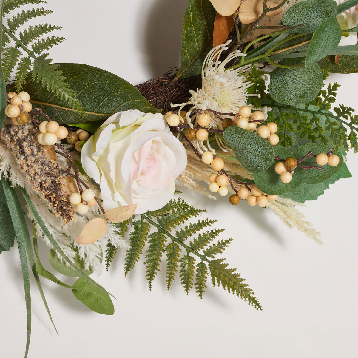 A pale rose nestles among delicate ferns, berries, and green leaves. || FXP1023A || detail_studio