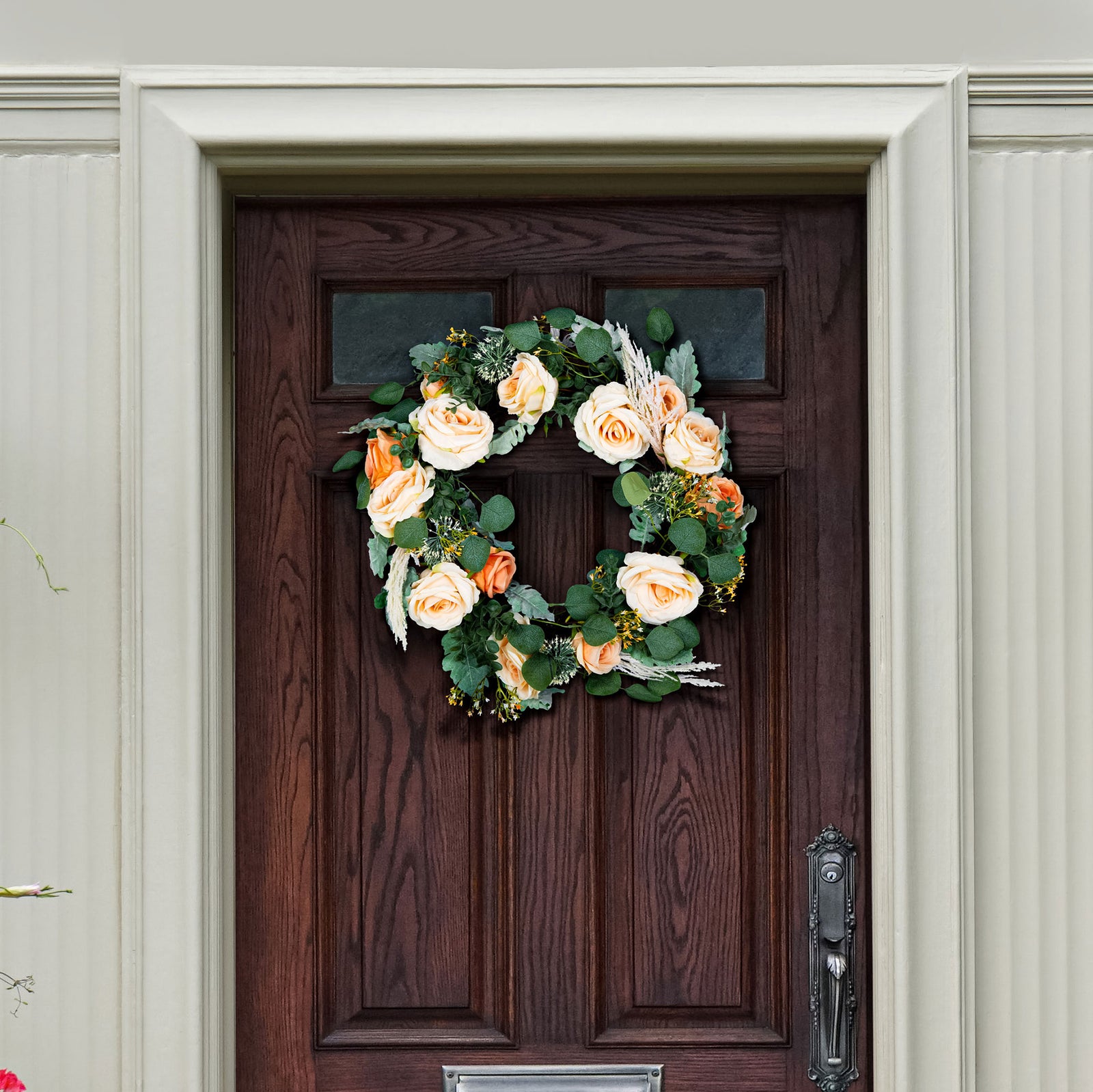 Peach roses and eucalyptus bring soft spring color to a wood door. || FXP1024A || front_room