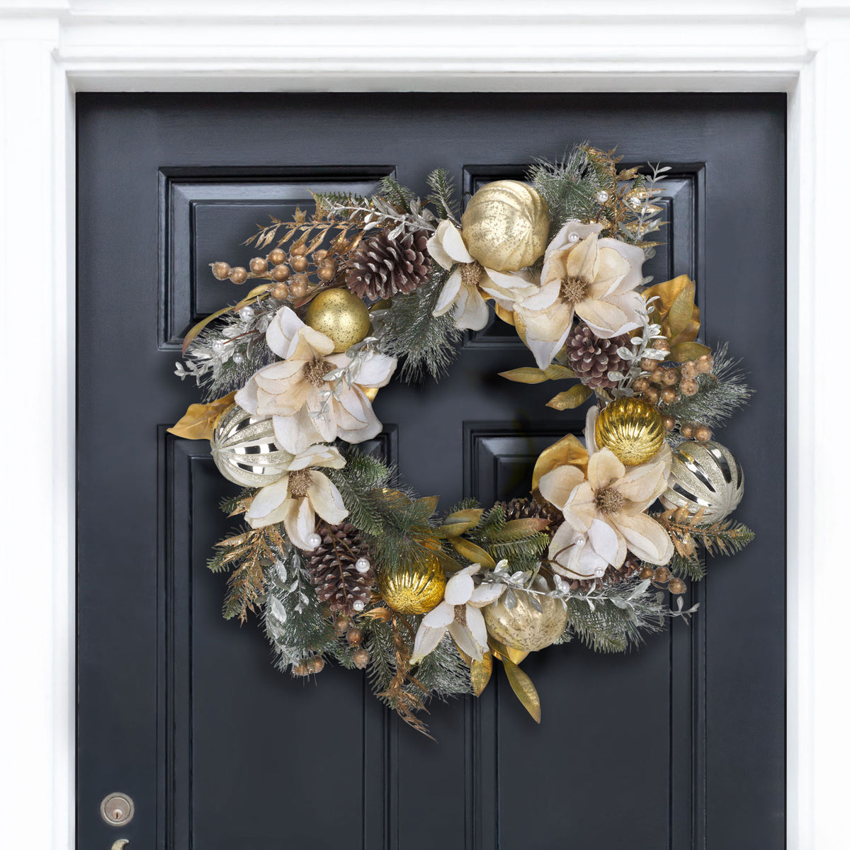 White poinsettias and gold ornaments brighten a dark entry door.