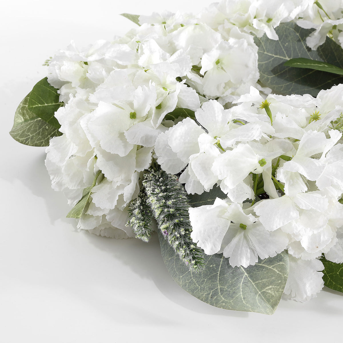 Soft white petals contrast with green magnolia leaves and fine sprigs. || FXP1037A || detail_studio