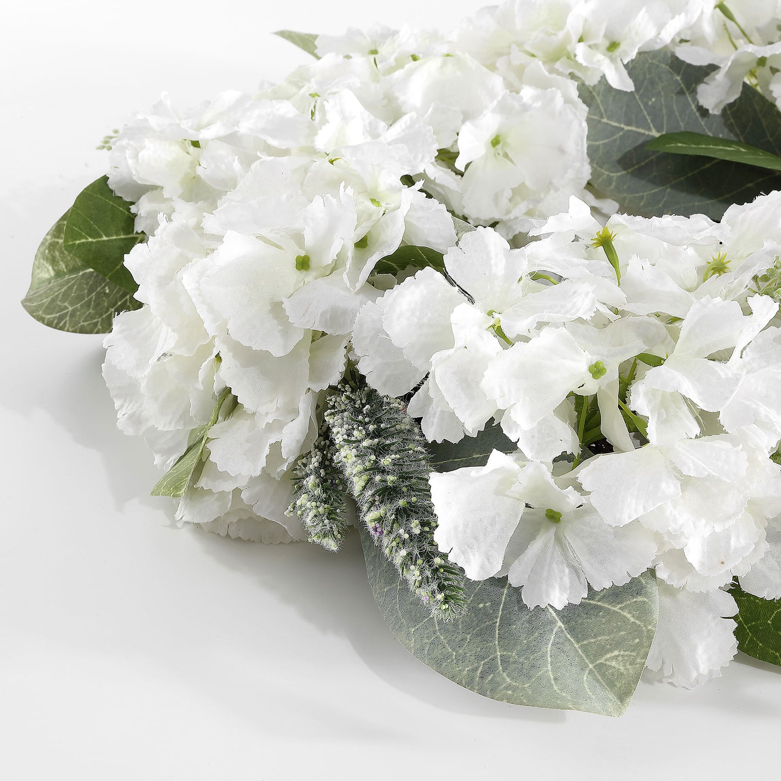 Soft white petals contrast with green magnolia leaves and fine sprigs. || FXP1037A || detail_studio