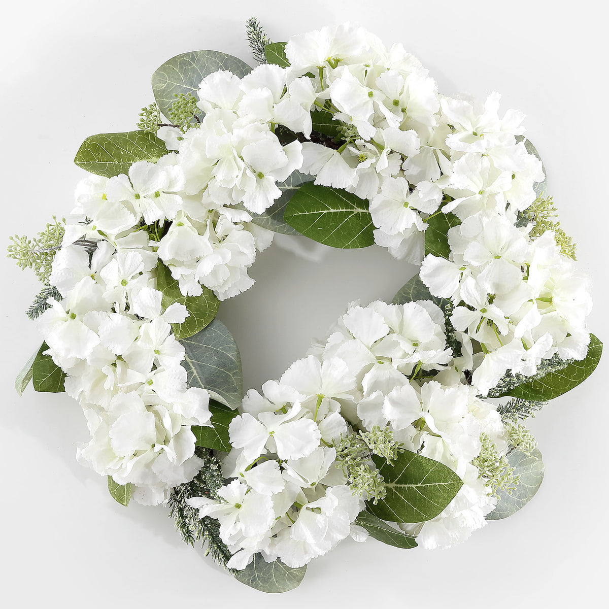 Abundant white hydrangeas form a bright ring with magnolia foliage. || FXP1037A || front_studio