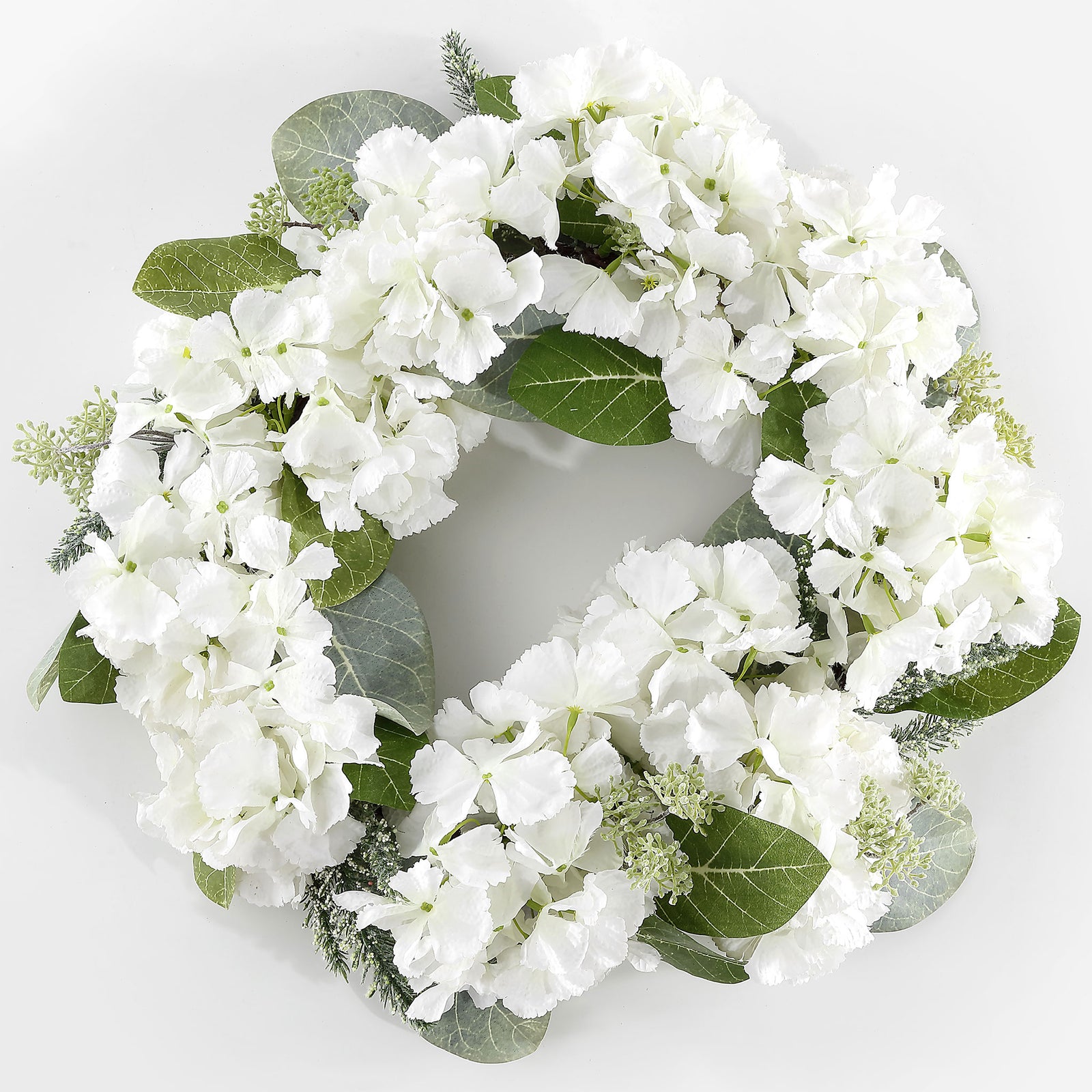 Abundant white hydrangeas form a bright ring with magnolia foliage. || FXP1037A || front_studio
