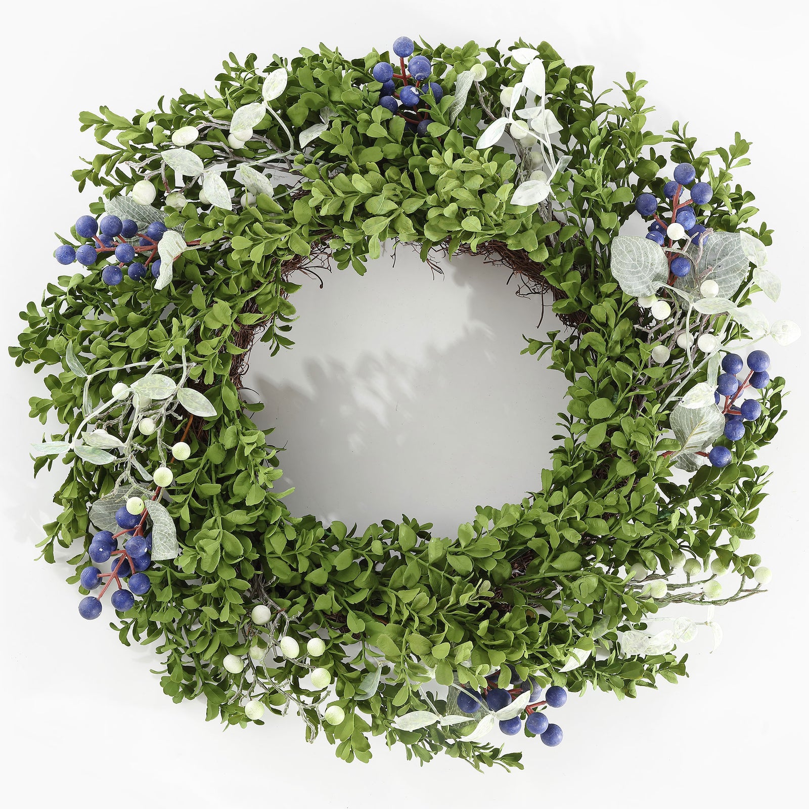 Lush boxwood foliage surrounds vivid blue berries and soft white accents. || FXP1038A || front_studio