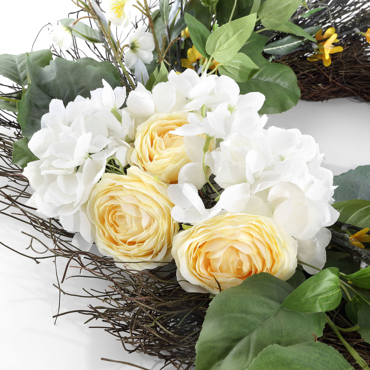 Creamy roselike blooms nestle among white hydrangeas and green leaves.