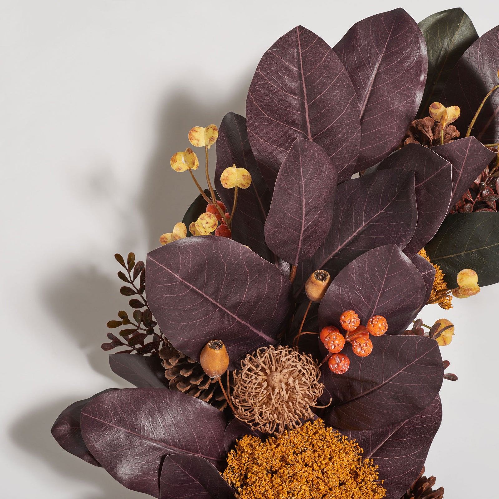 Deep plum leaves mingle with orange berries and textured seed pods. || FXP1047A || detail_studio