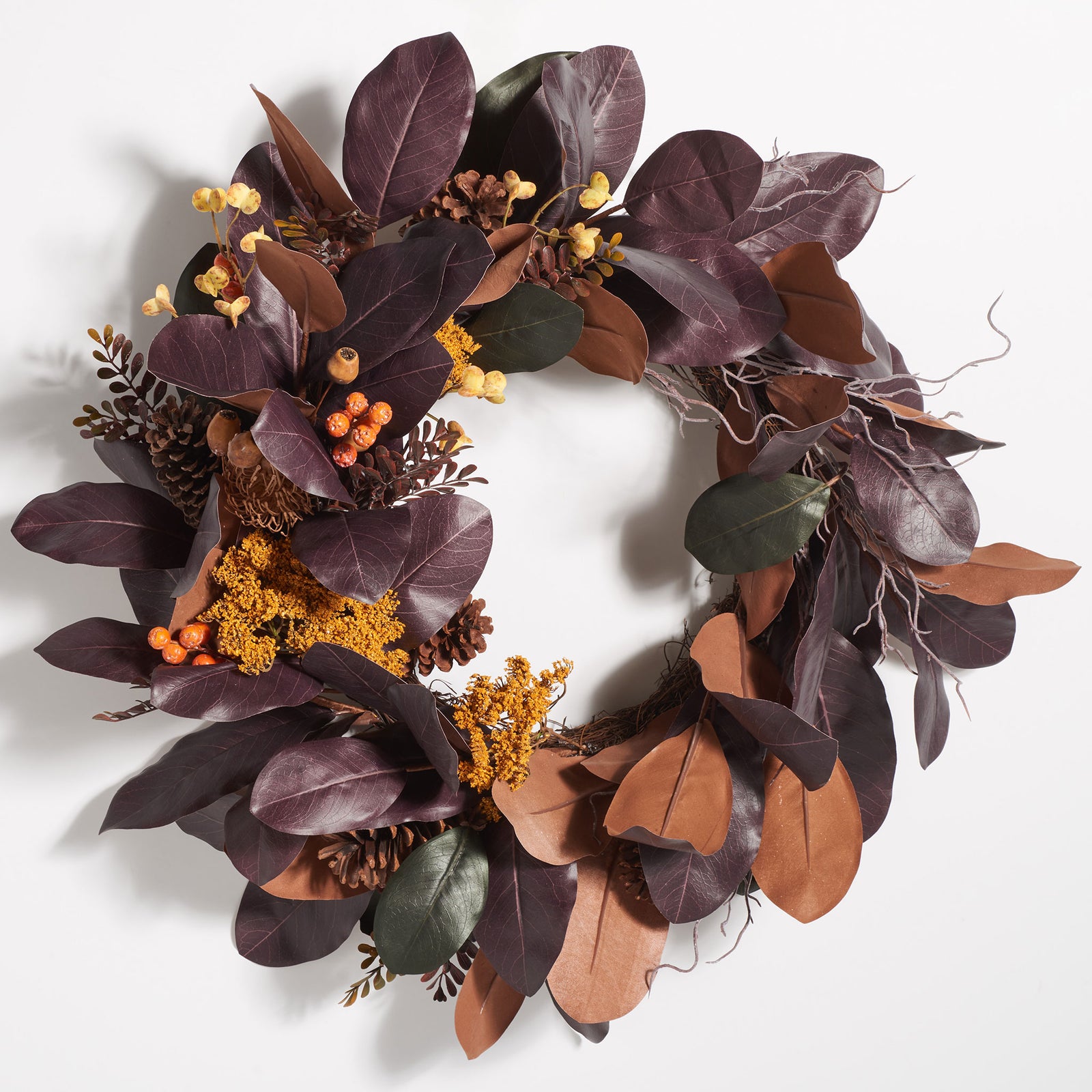 Shaded magnolia leaves frame golden sprigs and clusters of tiny fruit. || FXP1047A || front_studio
