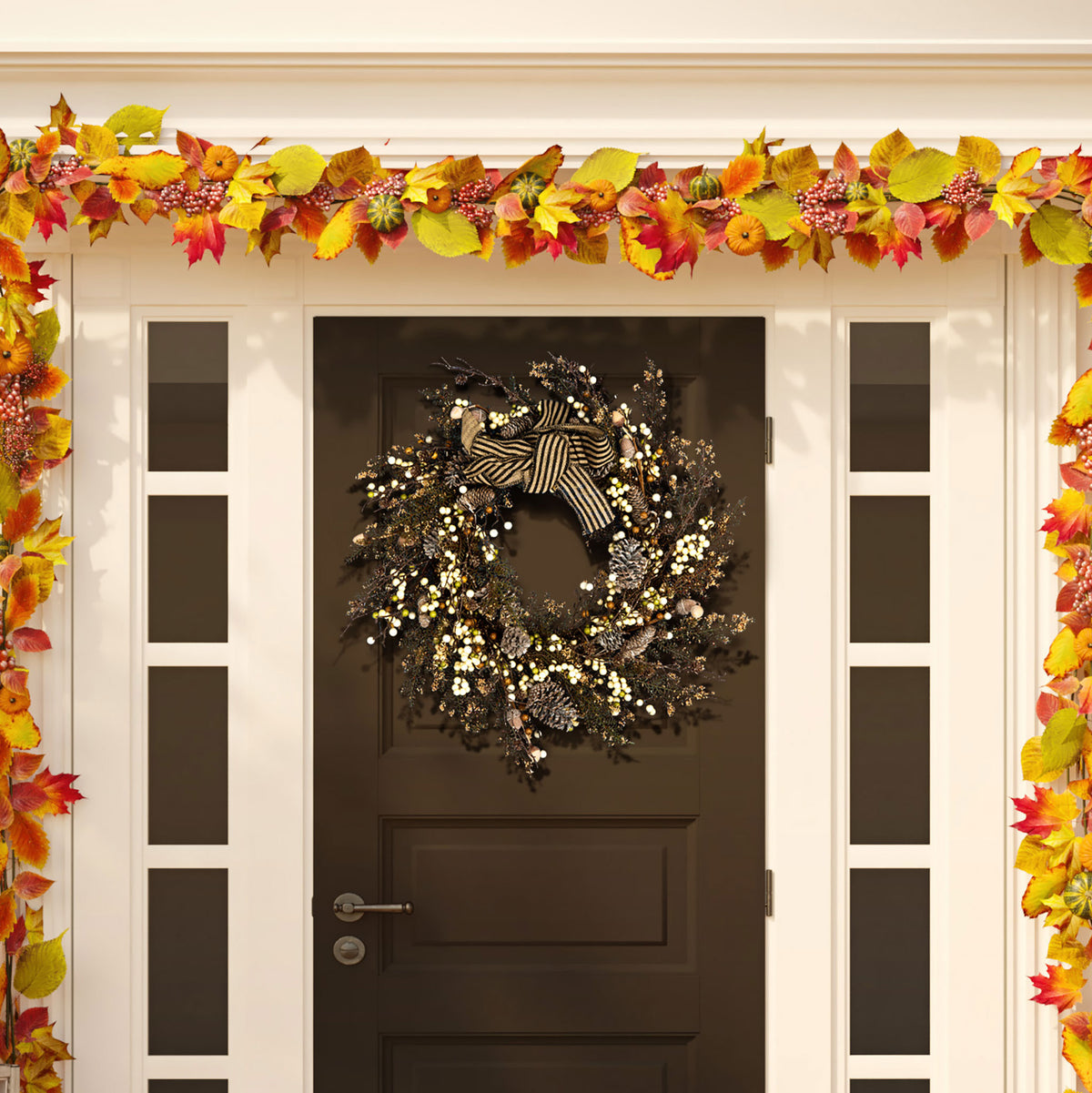 Cream berries and pine cones frame a bold striped bow on a fall wreath.