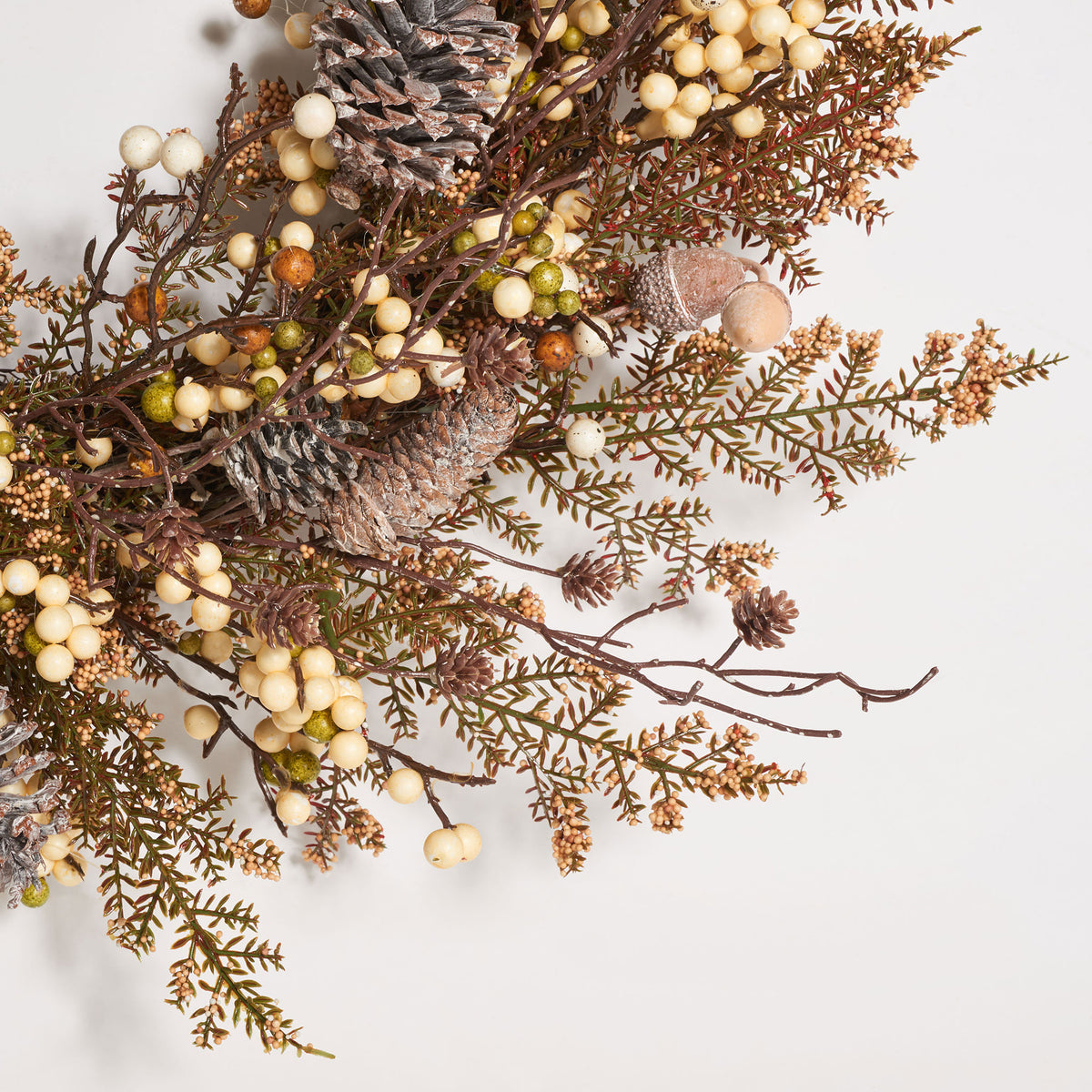 Ivory berries nestle among feathery brown sprigs and textured pine cones. || FXP1055A || detail_studio