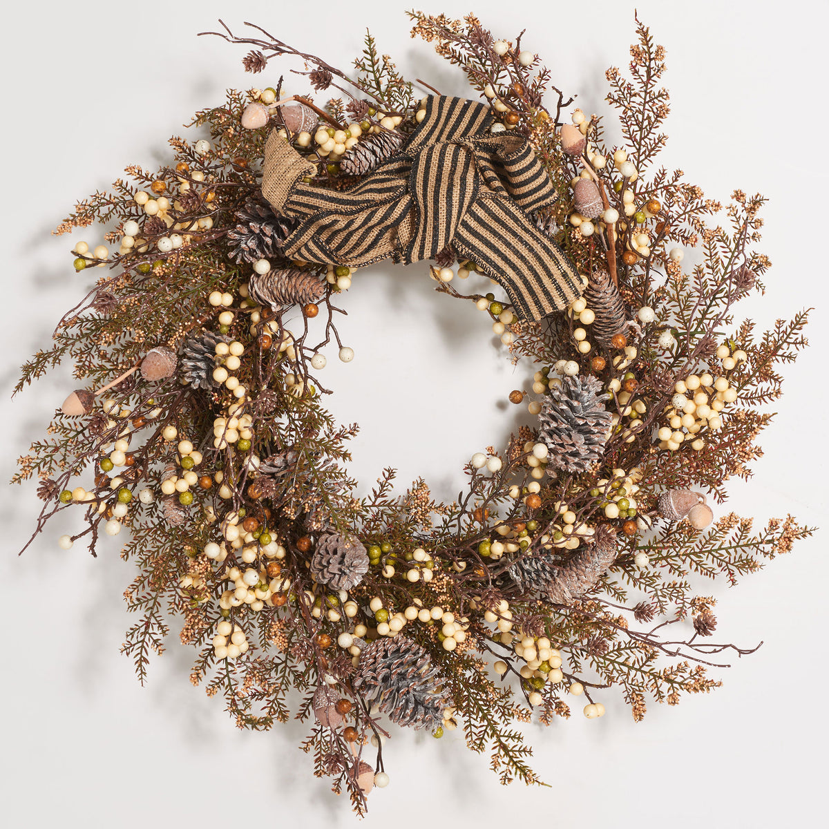 A striped bow crowns an earthy wreath of cream berries and pine cones. || FXP1055A || front_studio