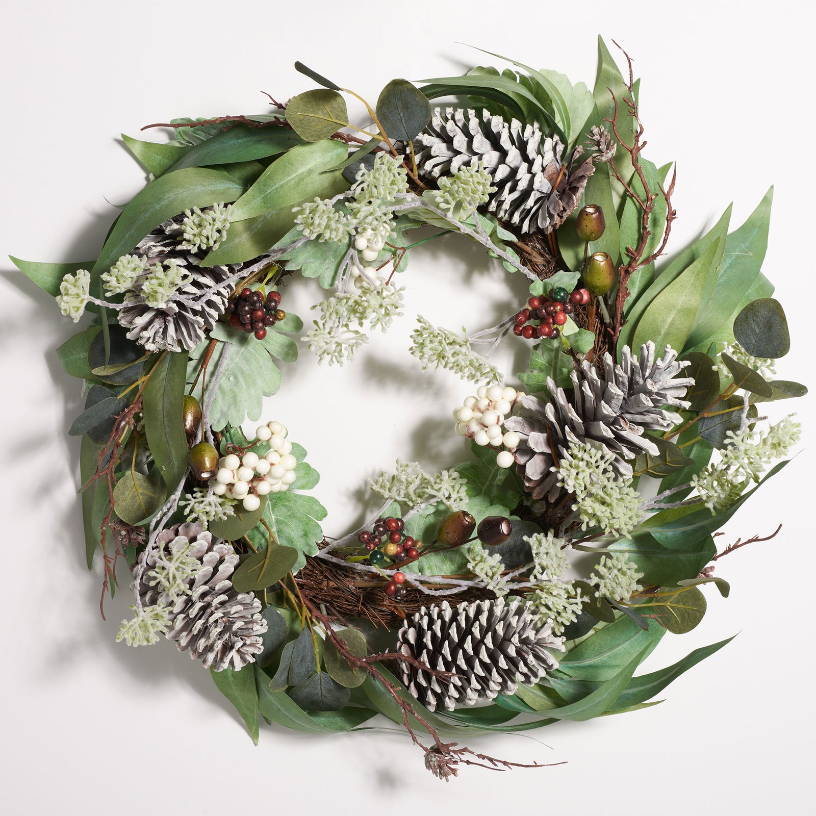 Soft green foliage surrounds pale pine cones and red and white berries. || FXP1072A || front_studio