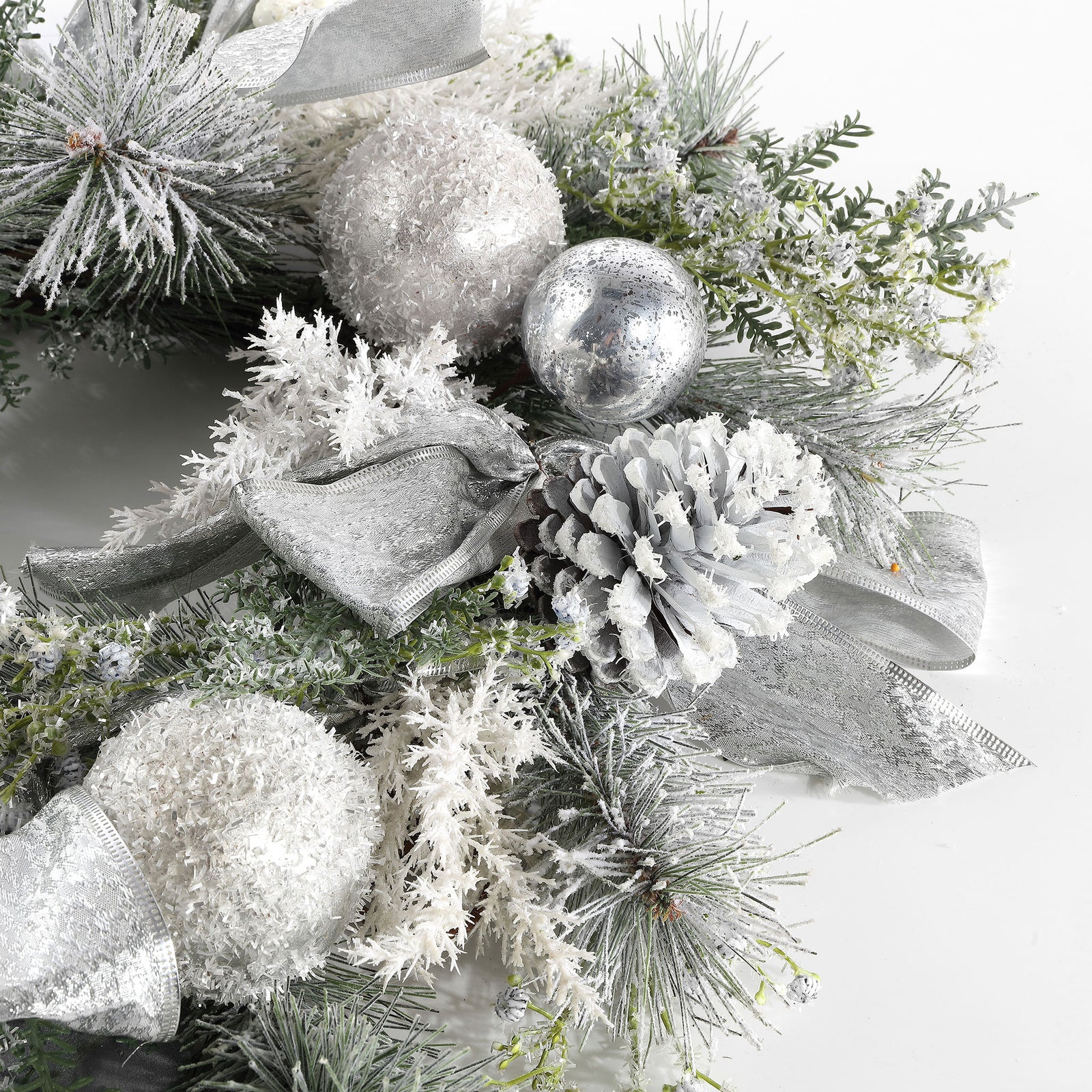 A pale pine cone nestles among glittering silver ornaments and snowy sprigs. || FXP1077A || detail_studio