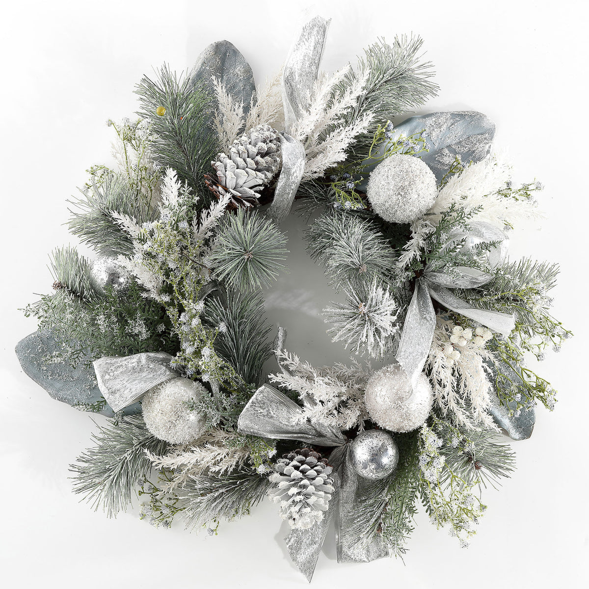 Snow-dusted pine and silver decorations create a bright holiday wreath. || FXP1077A || front_studio