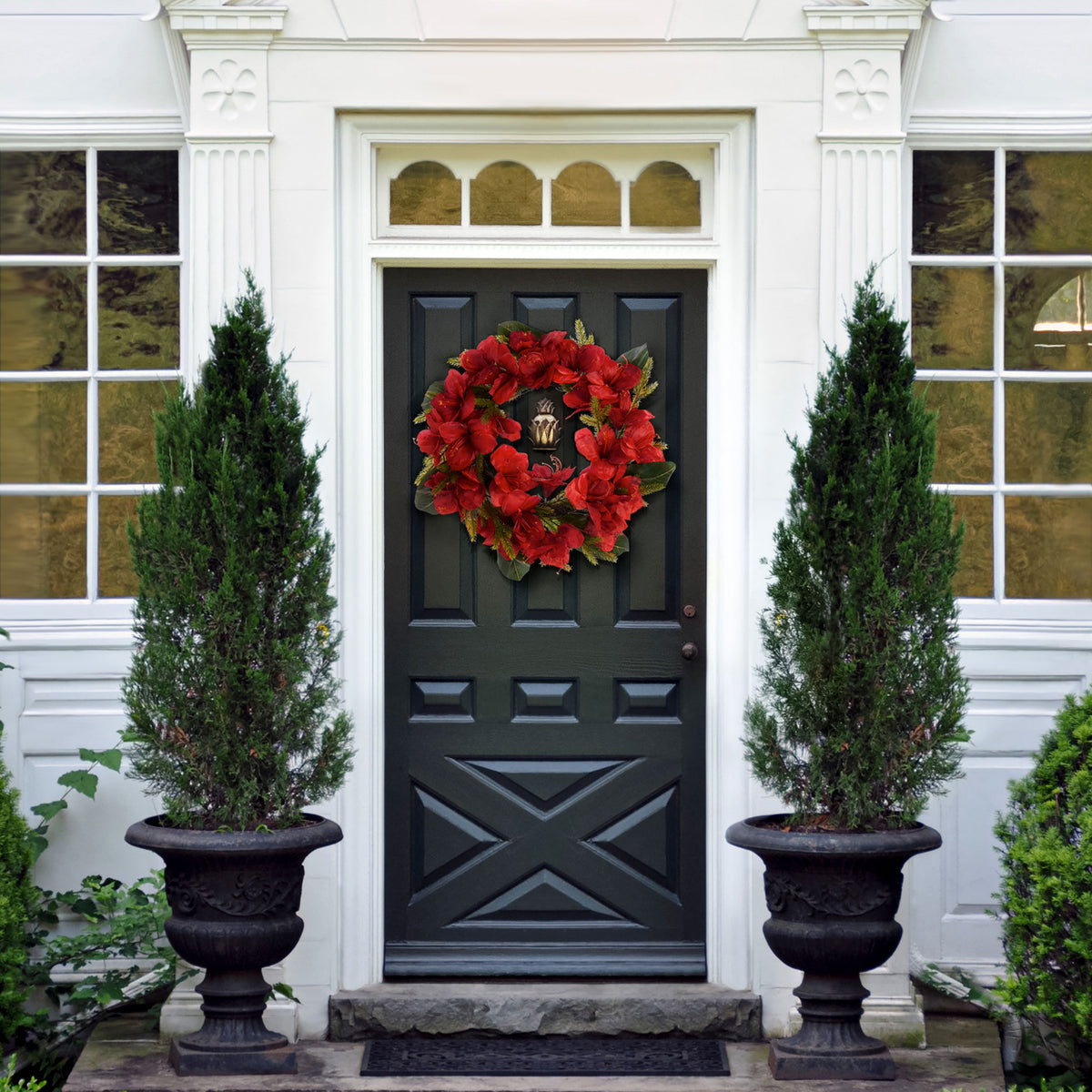 A bright red floral wreath adds a welcoming holiday accent to a dark door. || FXP1091A || front_room