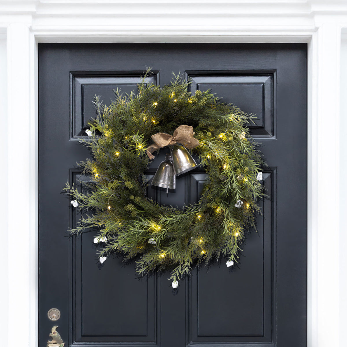 Warm lights twinkle around pine greenery and hanging metal bells. || FXP1096A || front_on_room