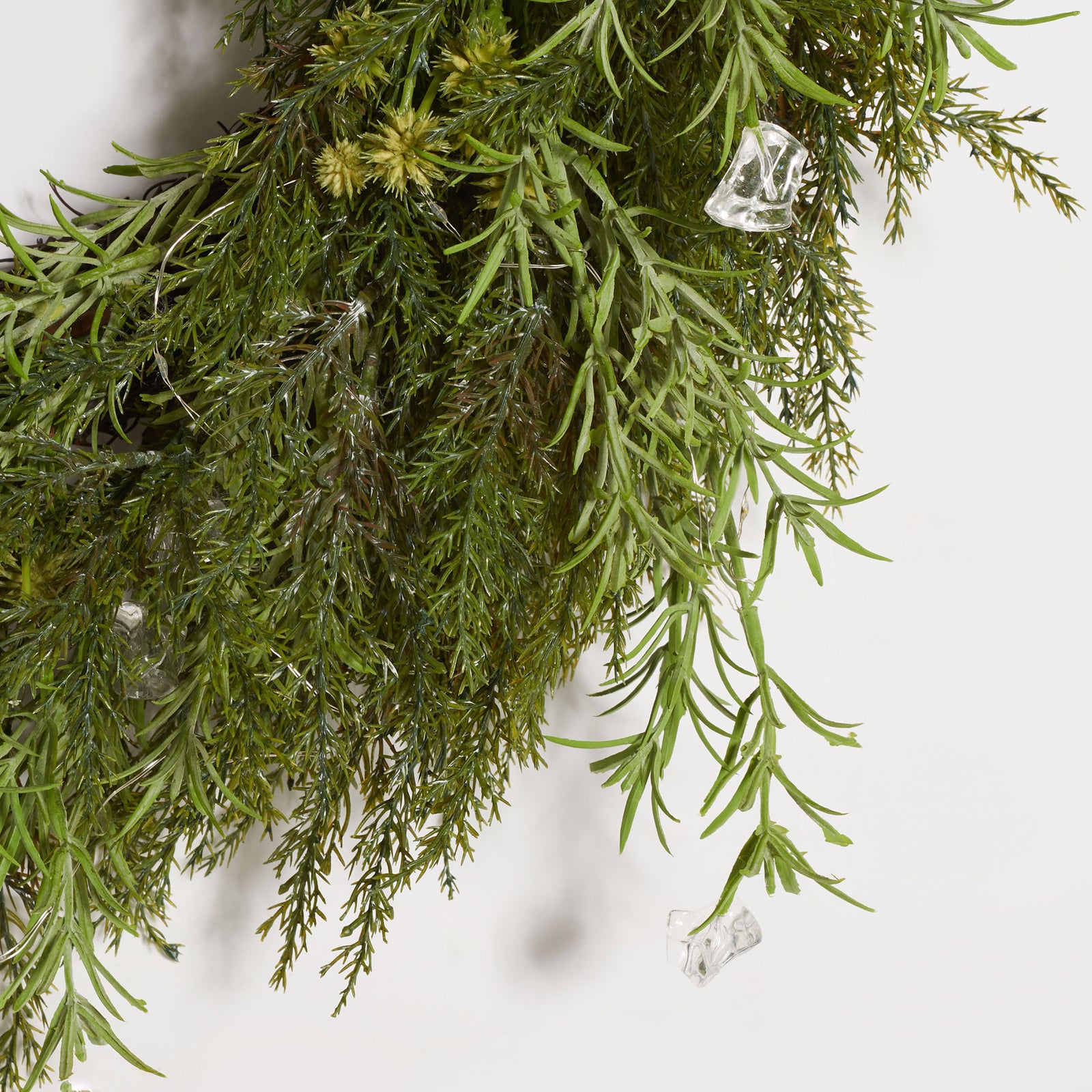 Fine green pine sprigs frame small clear LED bulbs. || FXP1096A || detail_studio