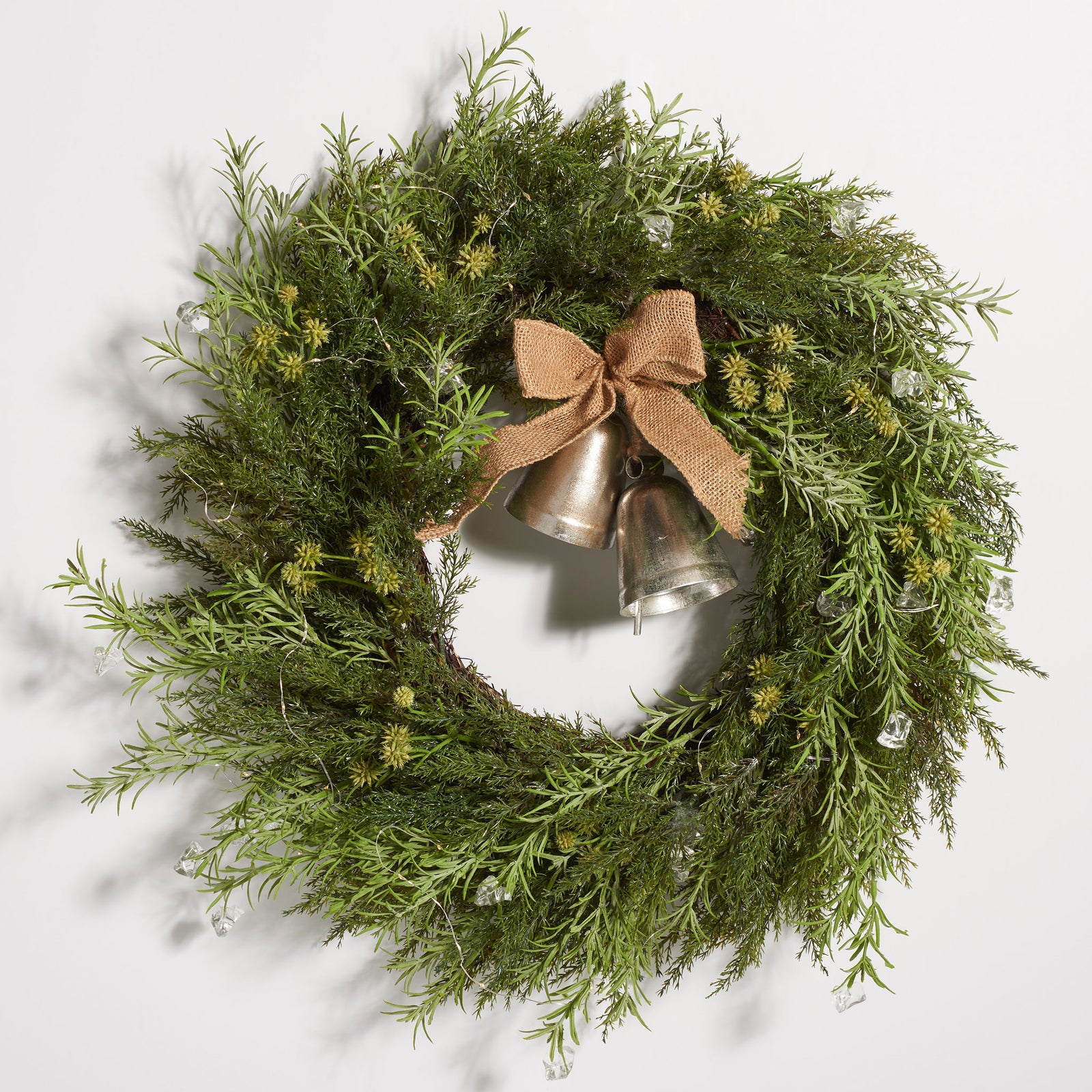A burlap bow and antique gold bells hang within a lush pine wreath. || FXP1096A || front_studio