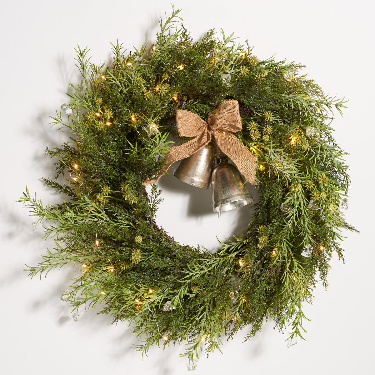 Glowing LED lights illuminate green pine boughs and rustic bells. || FXP1096A || front_on_studio