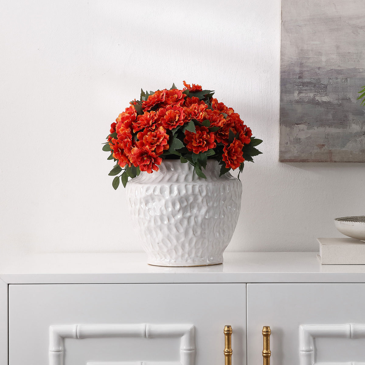 Vibrant marigolds brighten a white planter on a cabinet. || FXP2030A || front_room