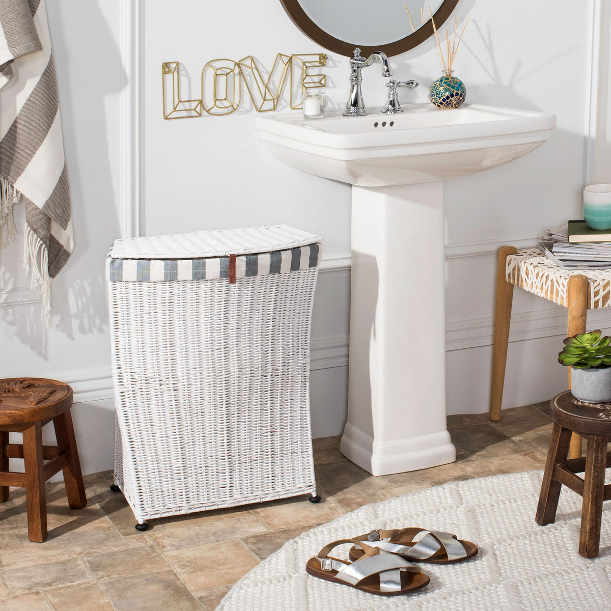 A slim white woven hamper with a fitted lid and striped trim brings neat storage beside a bathroom sink. || HAC6002A || front_room