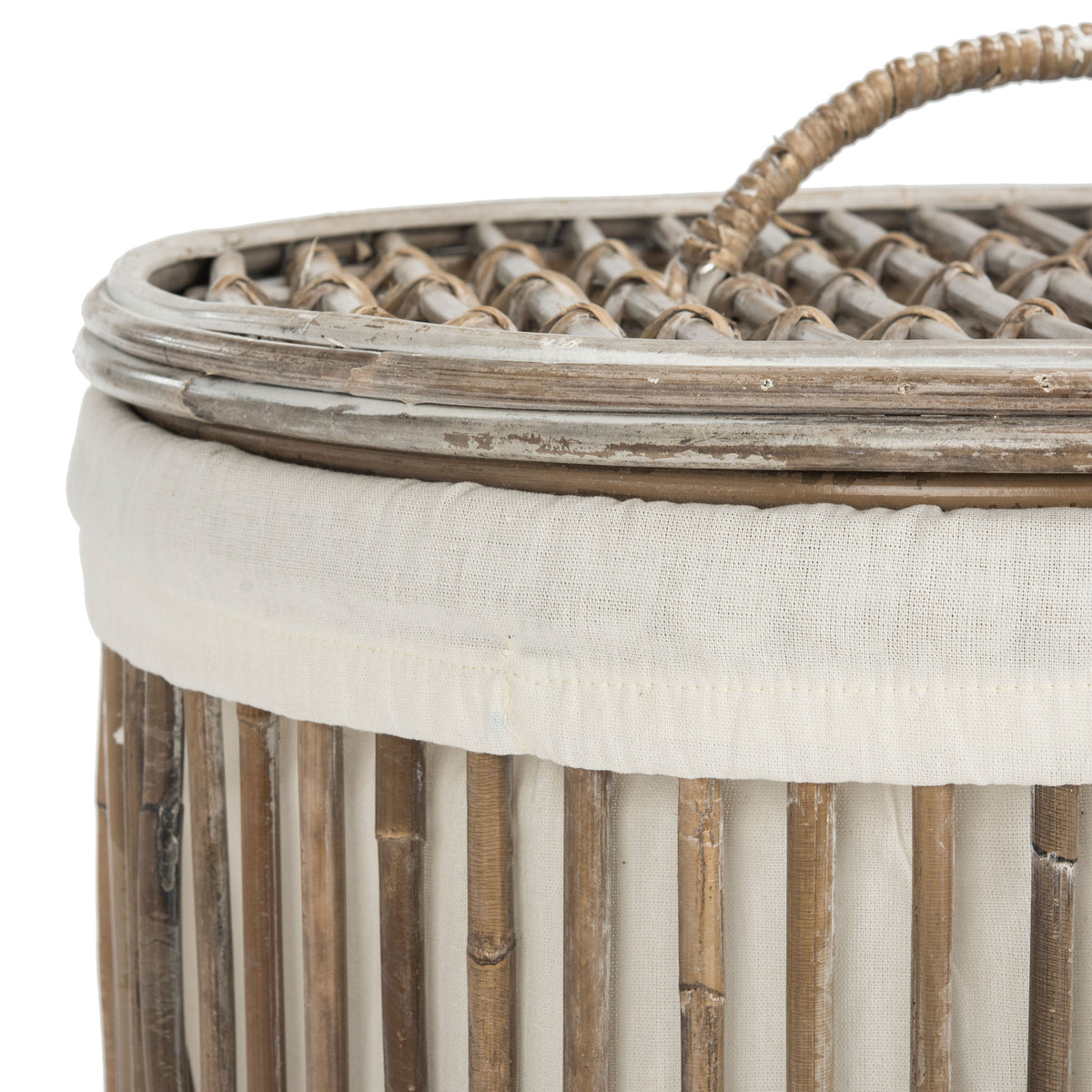 A woven rattan lid and loop handle complement the hamper's soft white liner