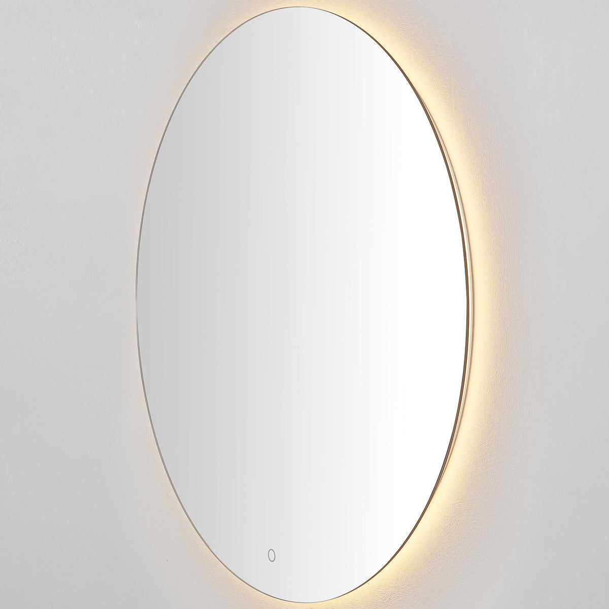 A silver-edged round mirror emits a warm golden halo from its LED backlight. || LMR1004A || side_on_studio
