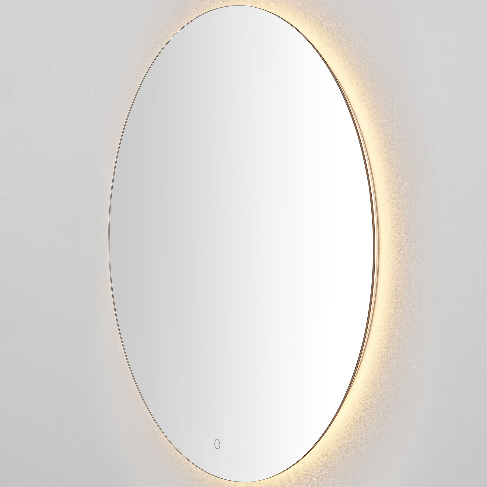 A silver-edged round mirror emits a warm golden halo from its LED backlight. || LMR1004A || side_on_studio