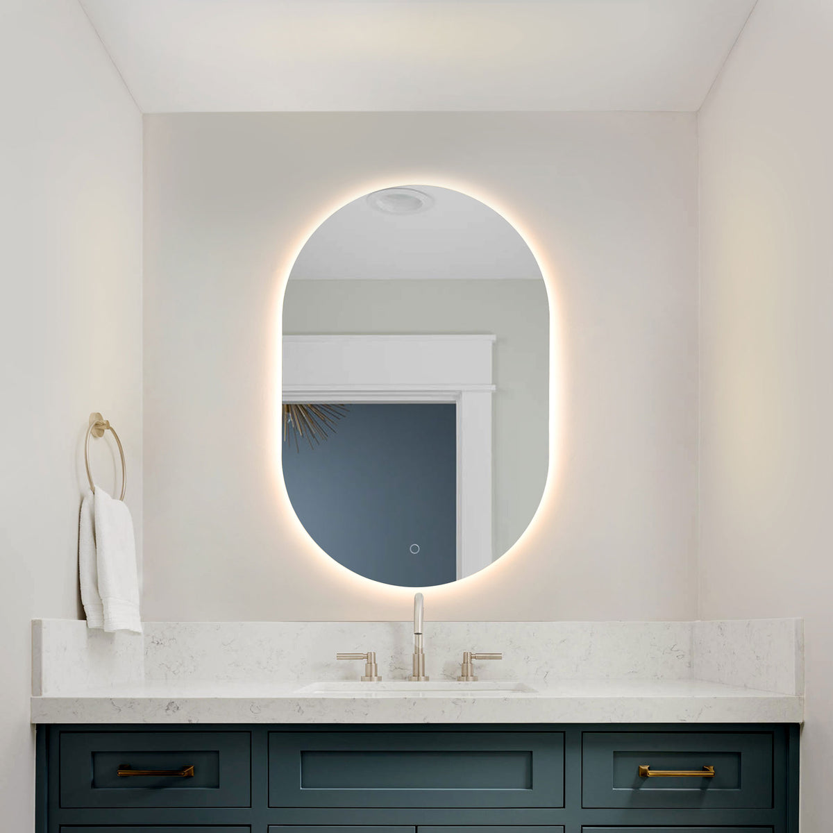 A glowing LED halo frames the rounded mirror above a blue bathroom vanity.