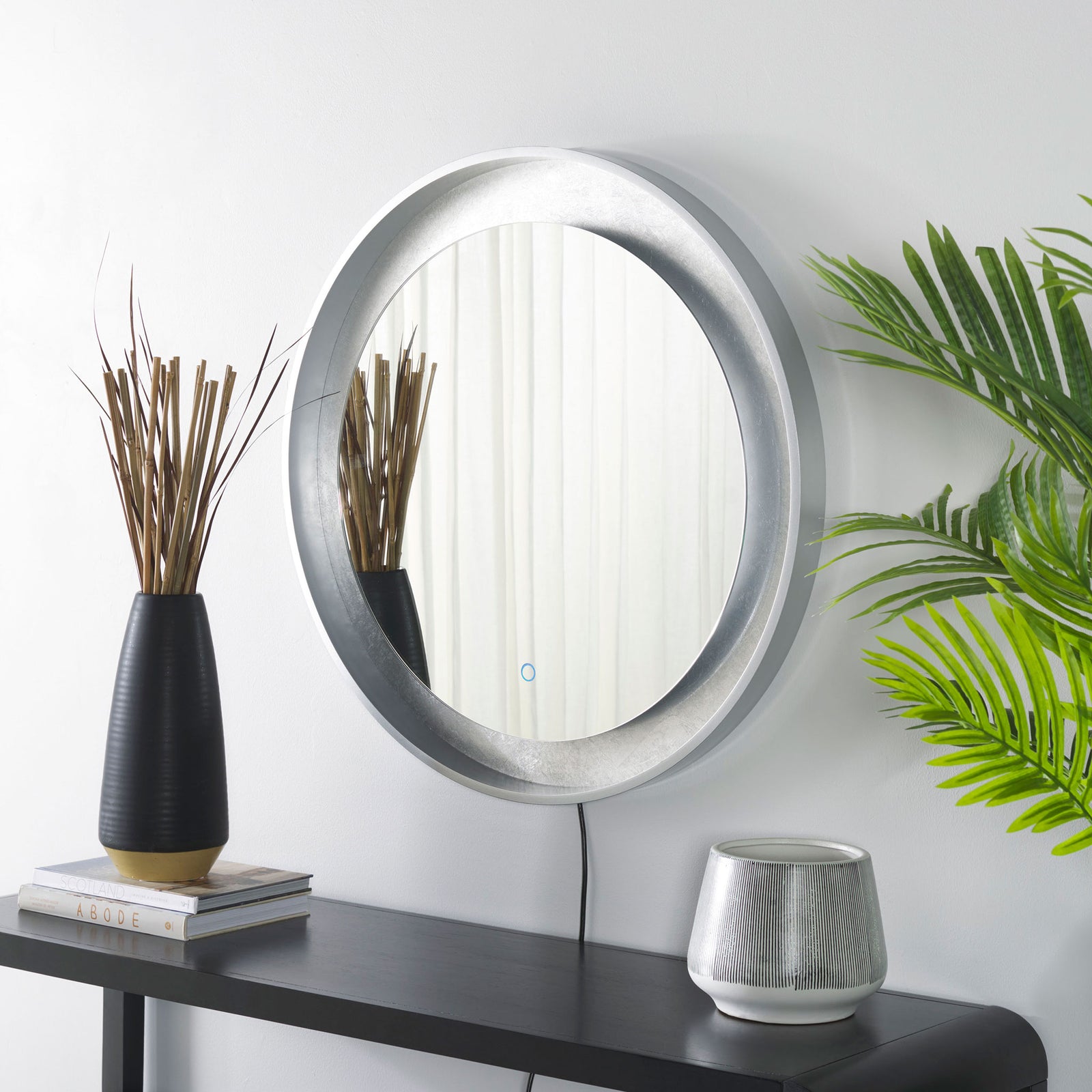 Silver-leaf trim and a silver-gray frame bring a subtle metallic accent above a dark console. || LMR1014A || front_angle_room