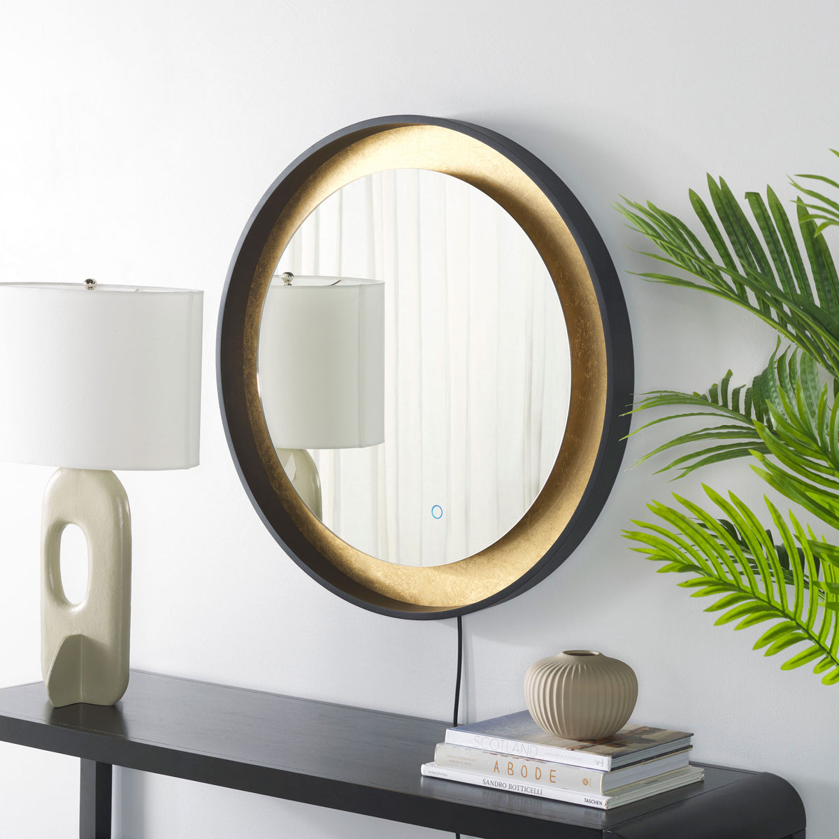 Black edging and textured gold leaf make this round mirror a warm accent above a console. || LMR1014B || front_angle_room