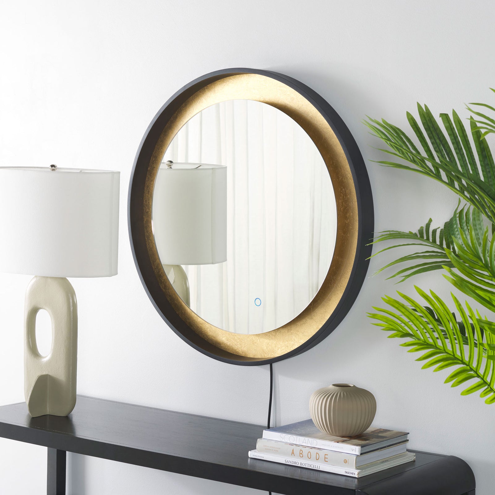 Black edging and textured gold leaf make this round mirror a warm accent above a console. || LMR1014B || front_angle_room