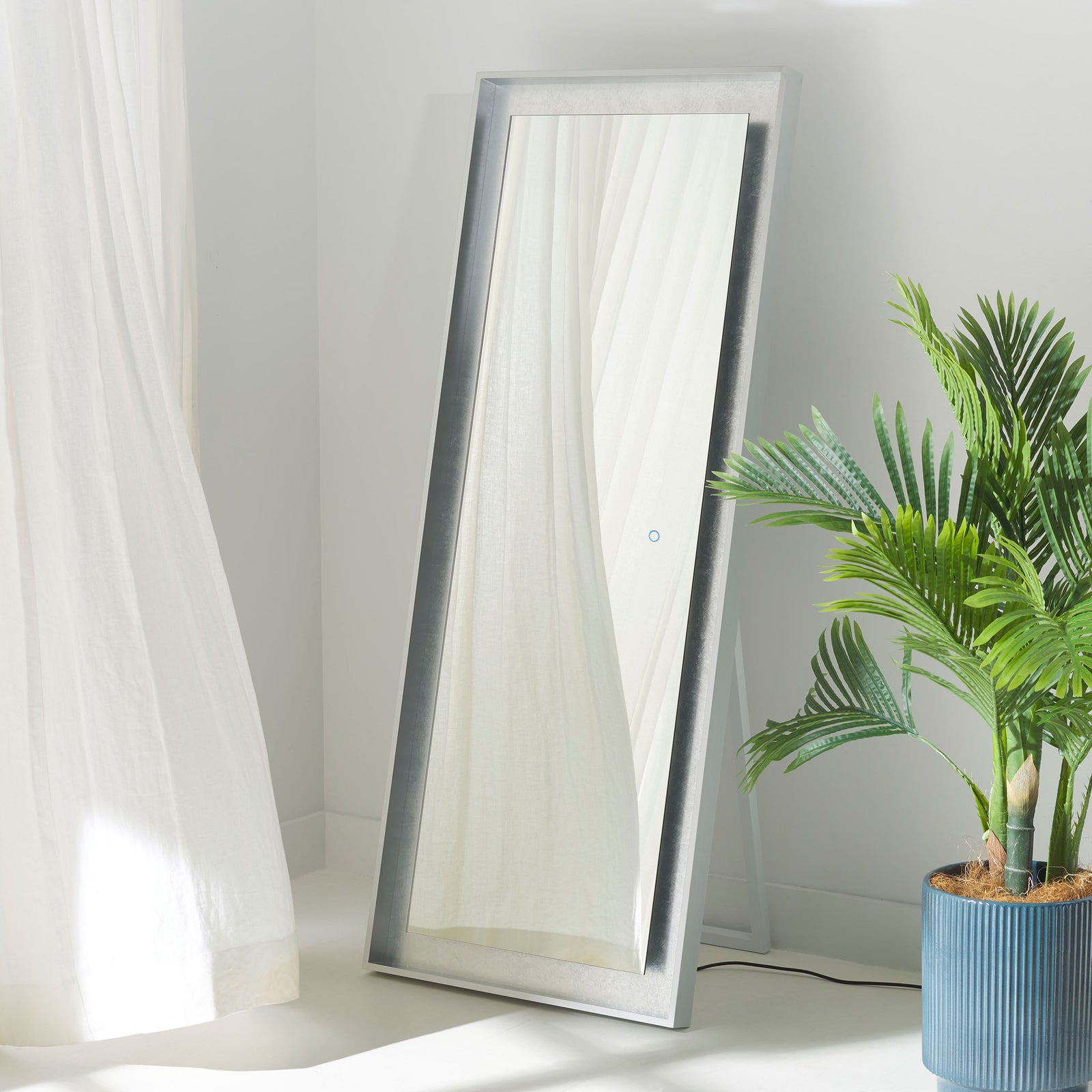 Shimmering silver leaf trim gives the full-length mirror a polished look on its freestanding support. || LMR1015A || front_angle_room
