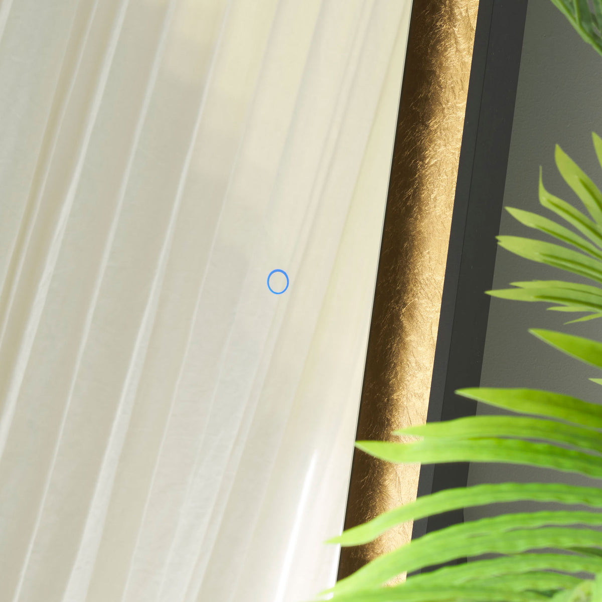 A blue touch control sits on the glass beside textured gold leaf trim and a slim black frame. || LMR1015B || detail_room