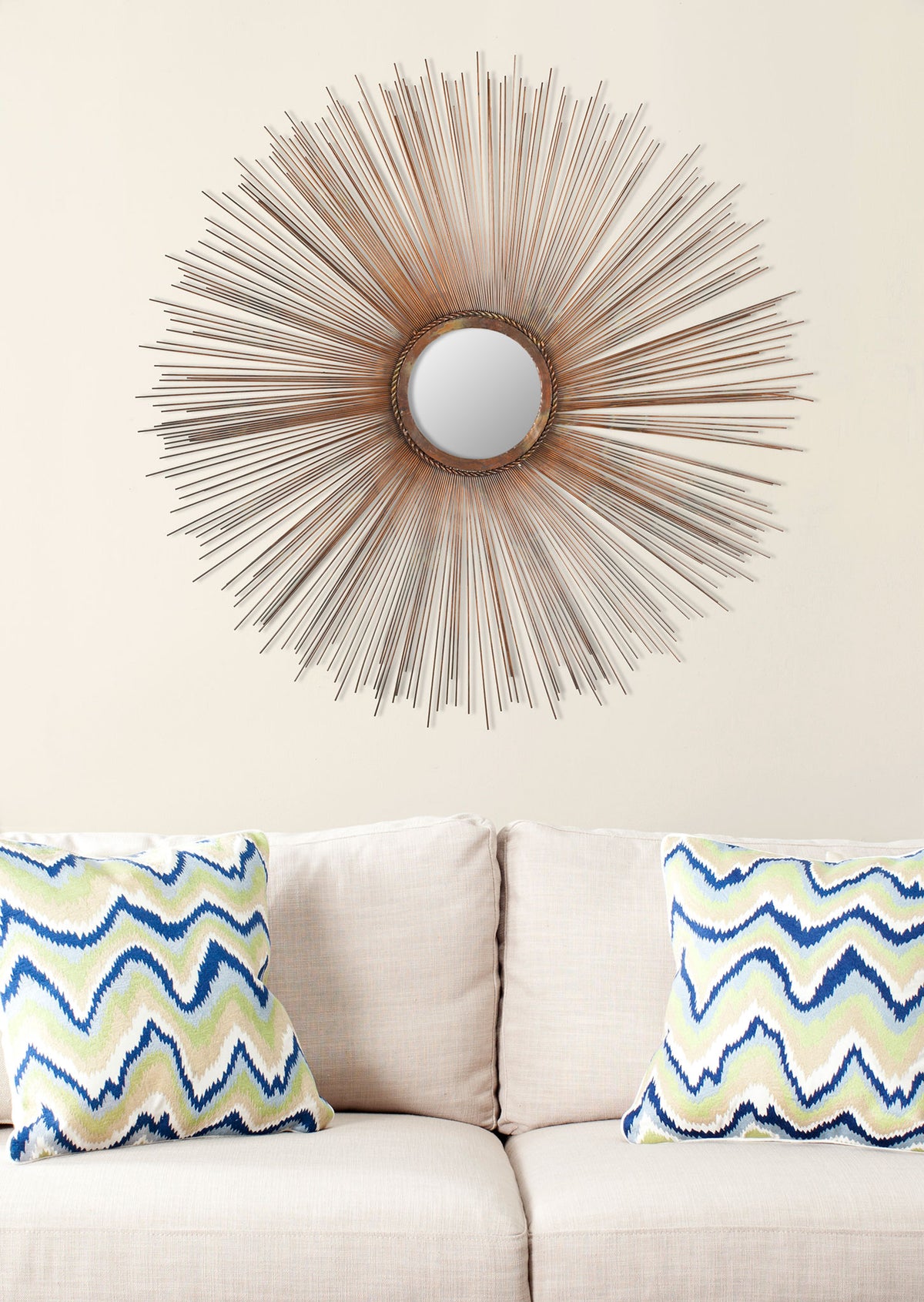 A copper sunburst mirror adds a radiant accent to the wall above a sofa || MIR3002A || front_room