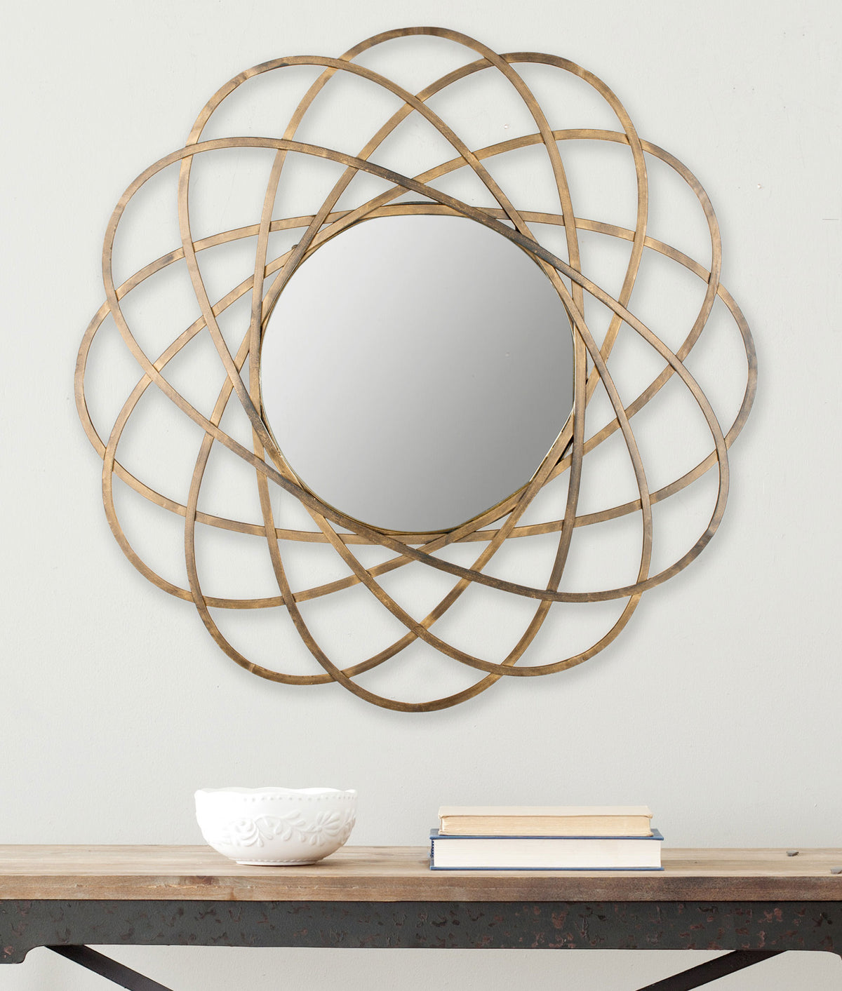 Overlapping gold loops encircle a round mirror, adding a sculptural accent to the wall || MIR4005A || front_room