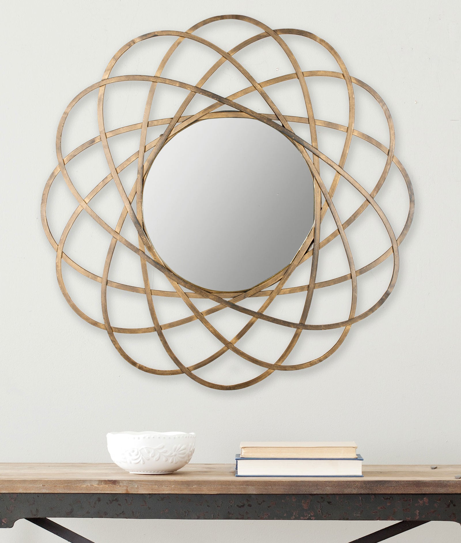 Overlapping gold loops encircle a round mirror, adding a sculptural accent to the wall || MIR4005A || front_room