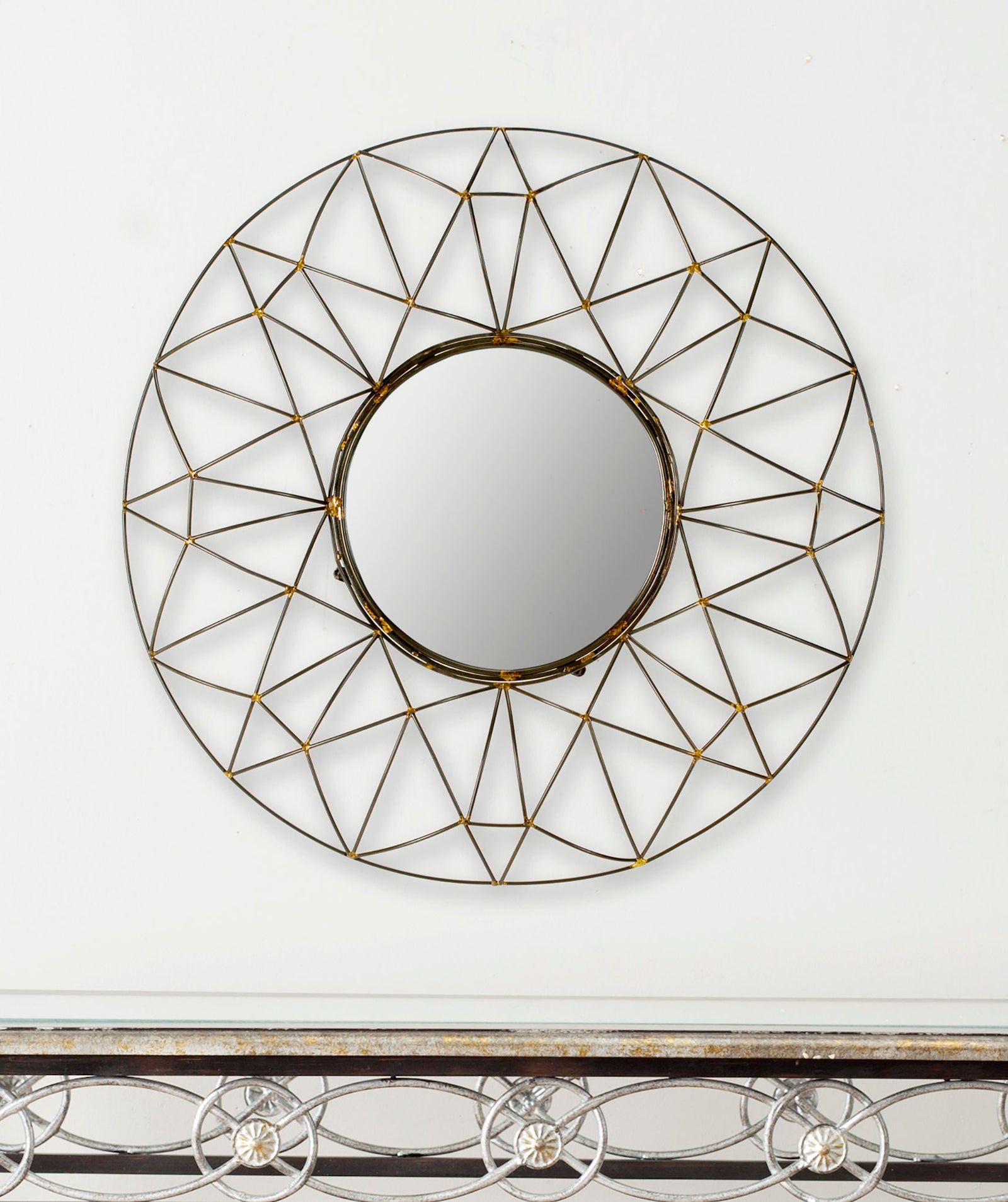 Round mirror with a compact reflective center and an open bronze frame of intersecting triangles. || MIR4015A || front_room