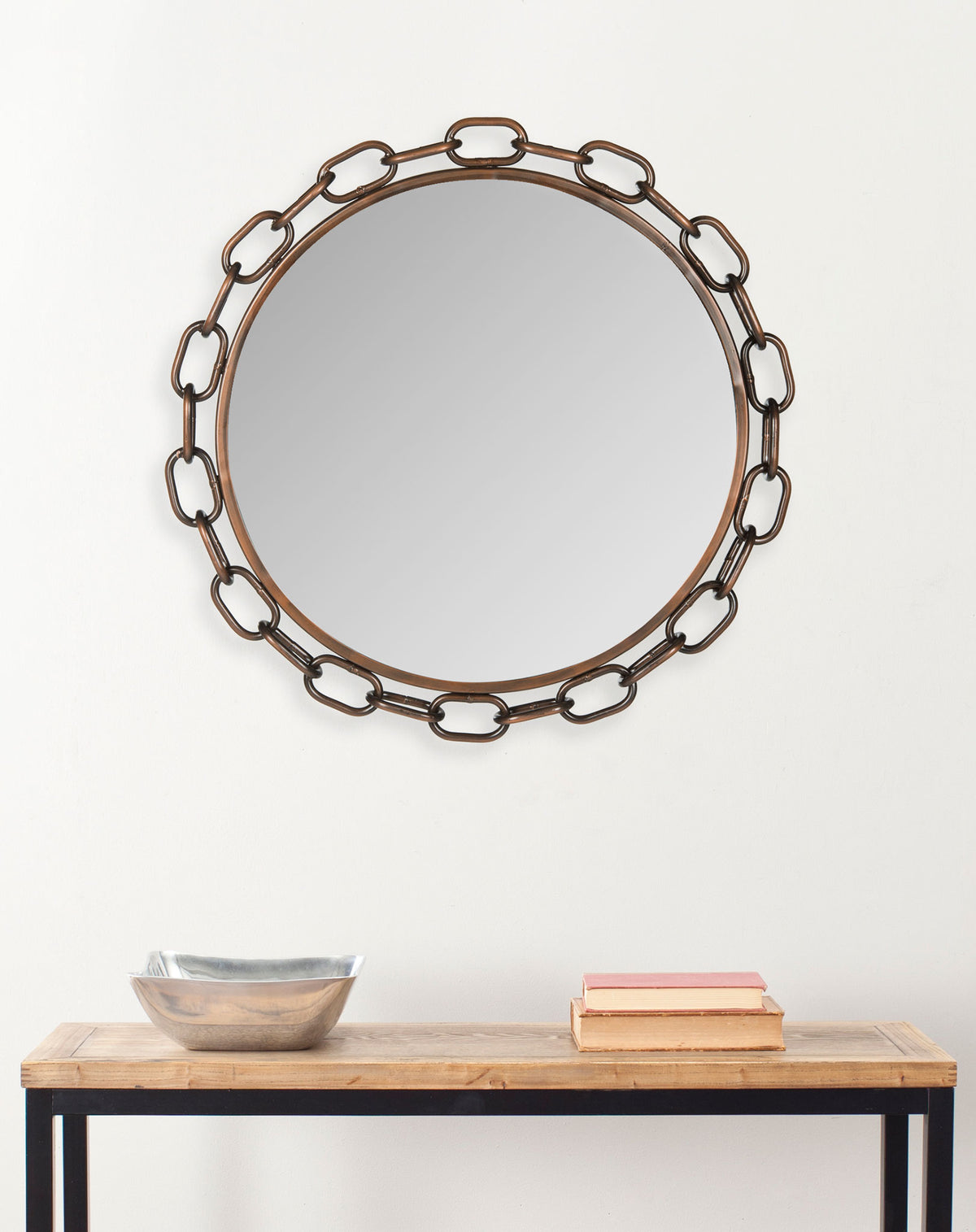 Round chain-link mirror adds a warm antique copper accent above a console table