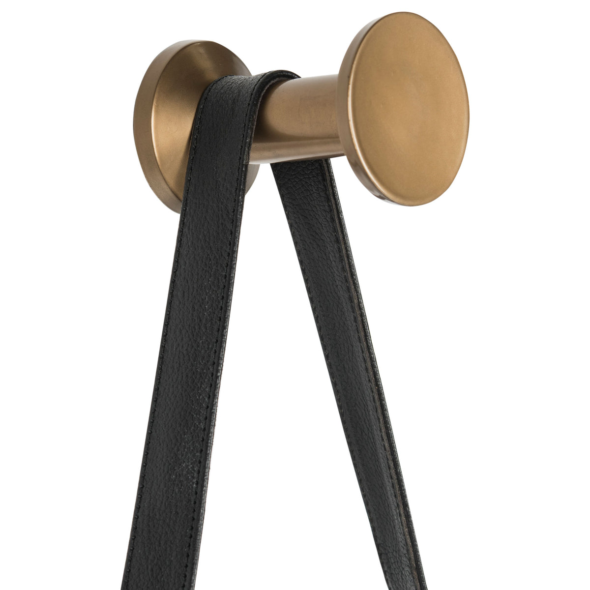 A black leather strap loops over a round antique gold wall peg for a refined finishing touch.