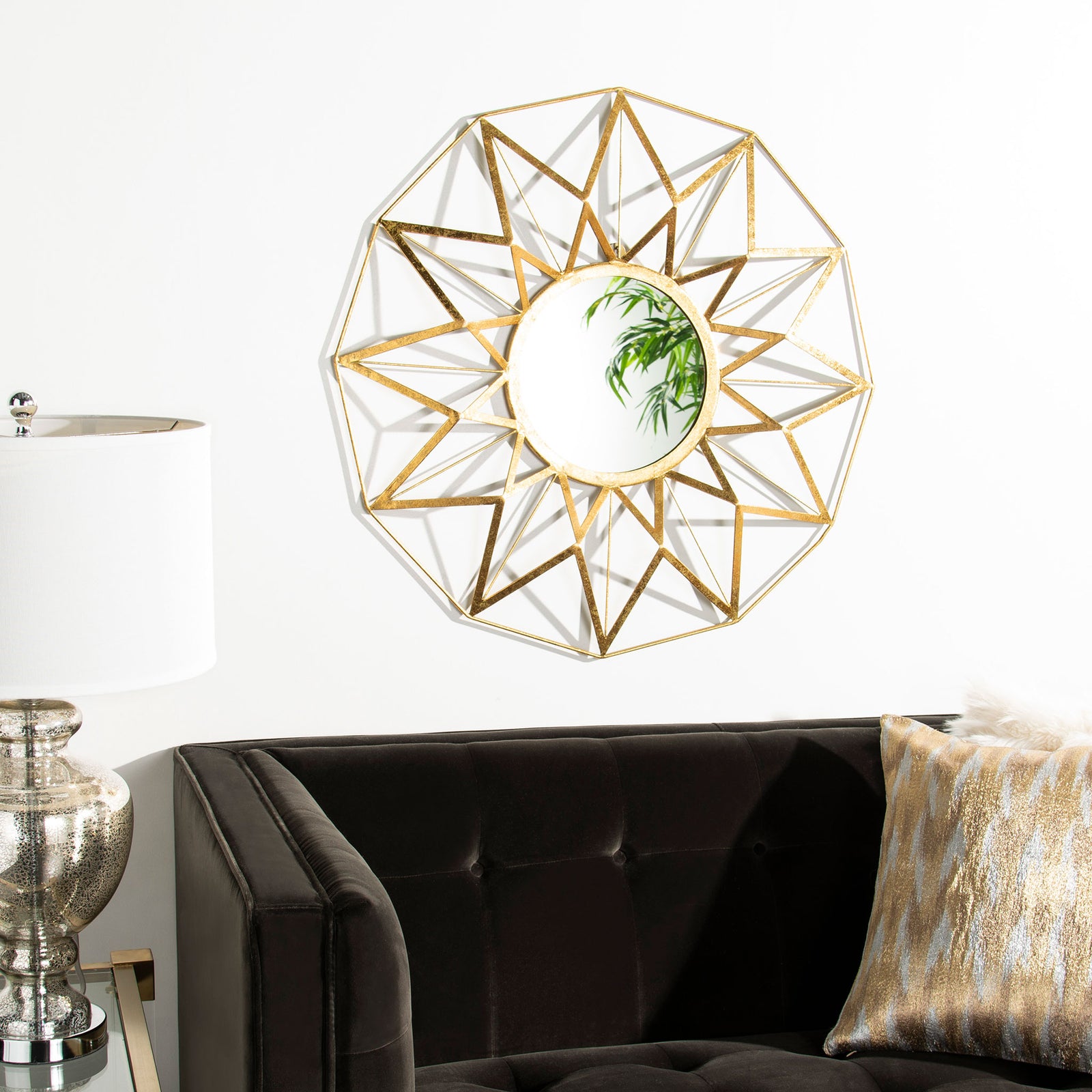 Gold starburst mirror creates a striking focal point above a dark sofa || MIR4099A || front_room