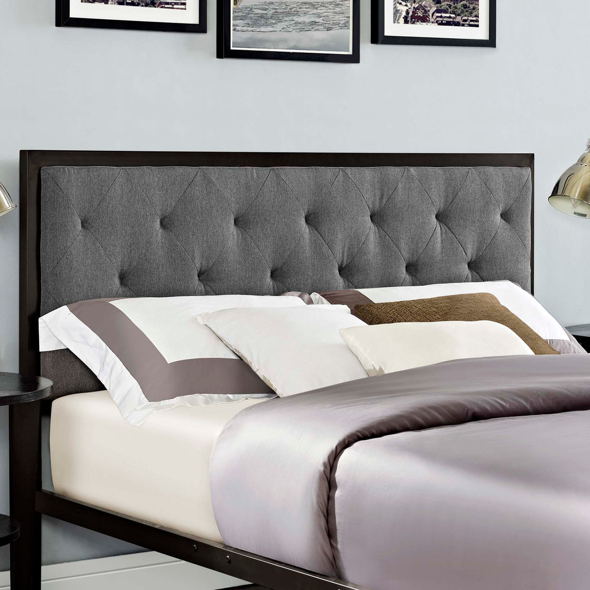 Gray diamond tufting and a dark frame add contrast behind the queen-size bed's layered pillows.