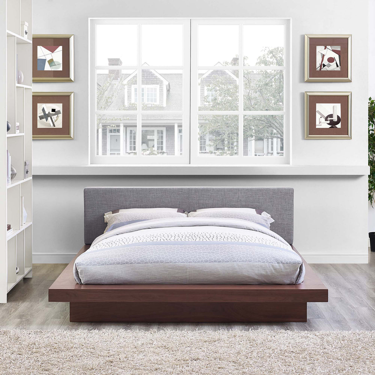 A low walnut platform and plush gray headboard bring understated style to the bedroom
