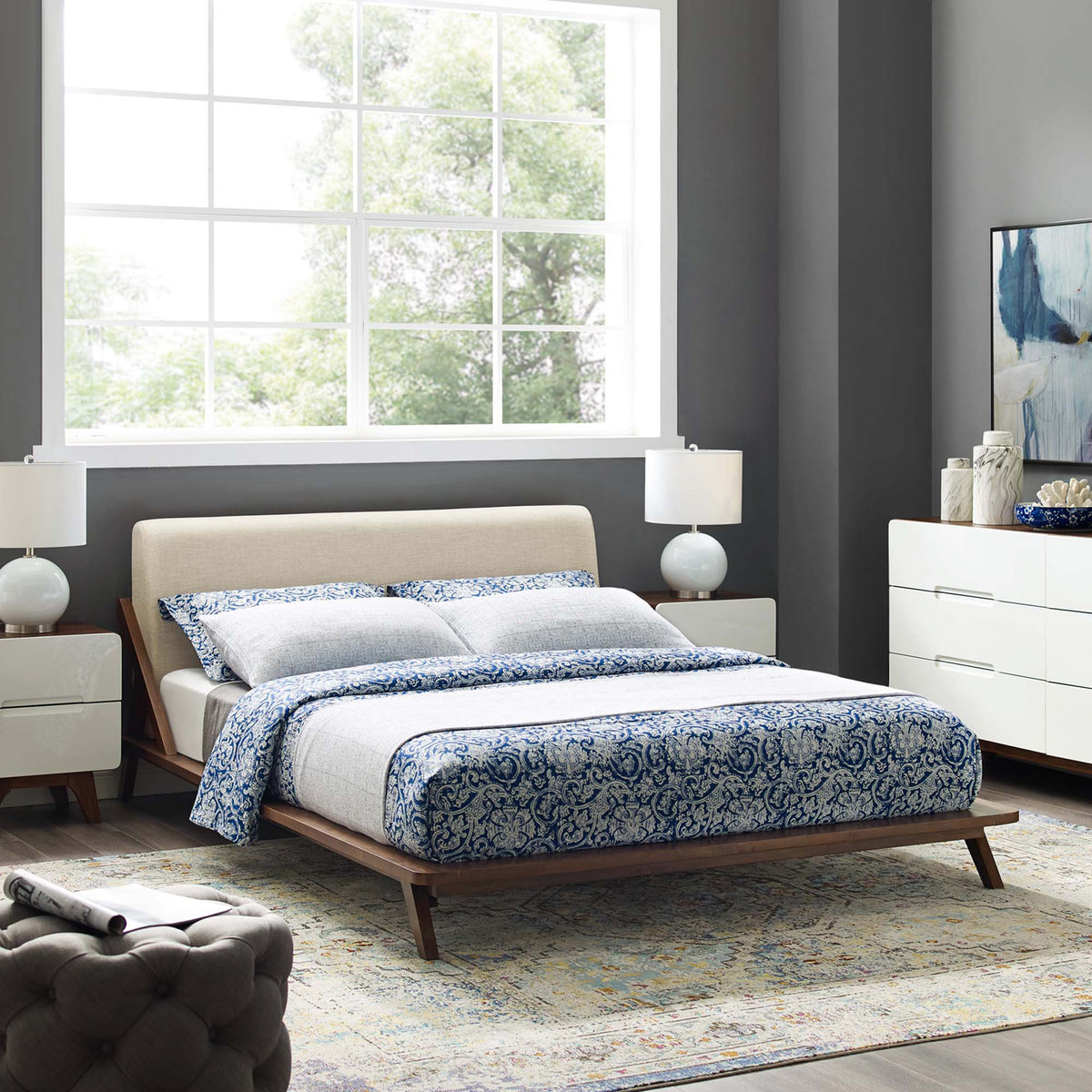 A beige fabric headboard and walnut-toned platform bring a warm, modern feel to the bedroom